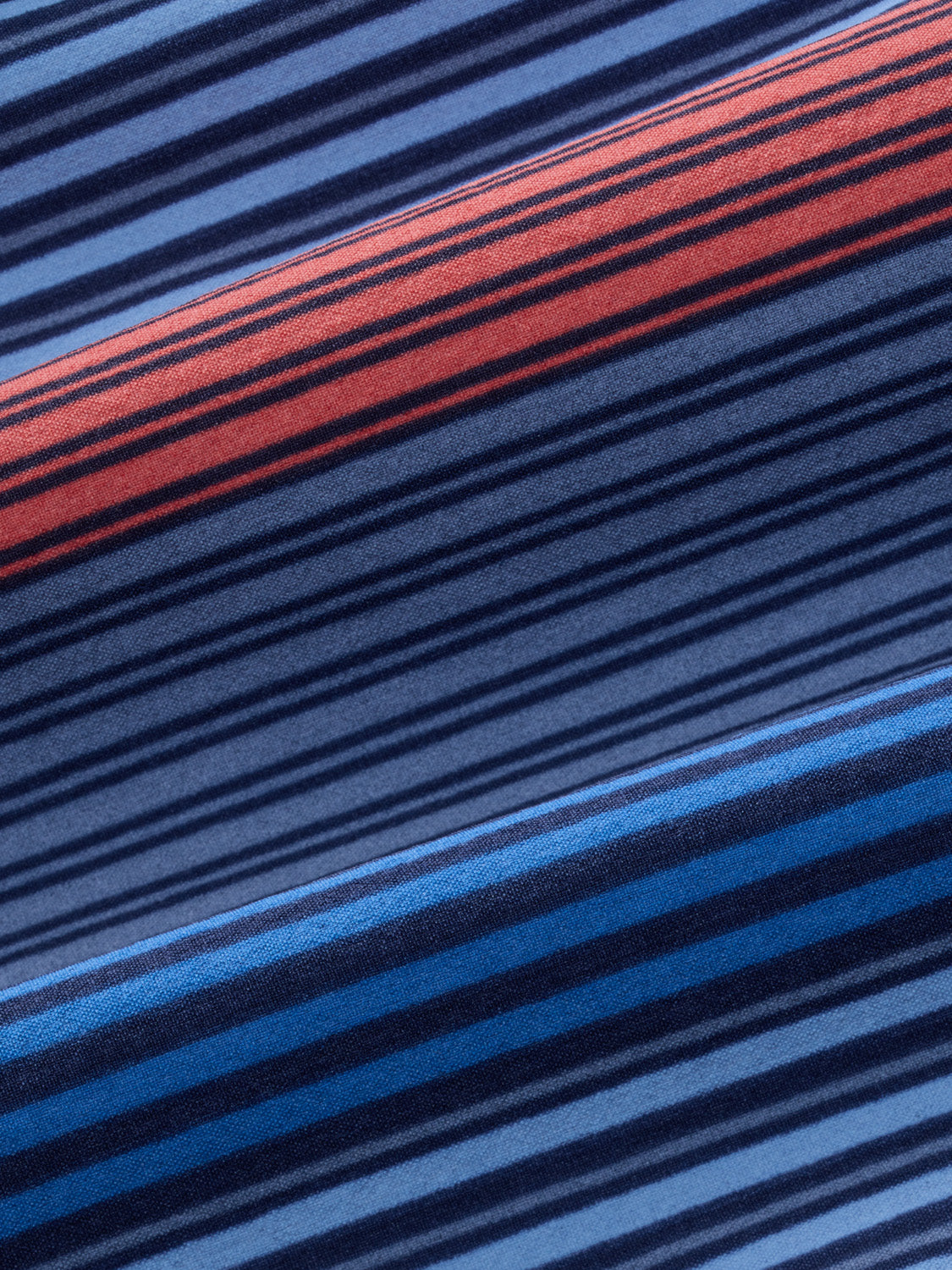 Fabric with horizontal stripes in blue, coral, and navy blue tones arranged diagonally across the surface.