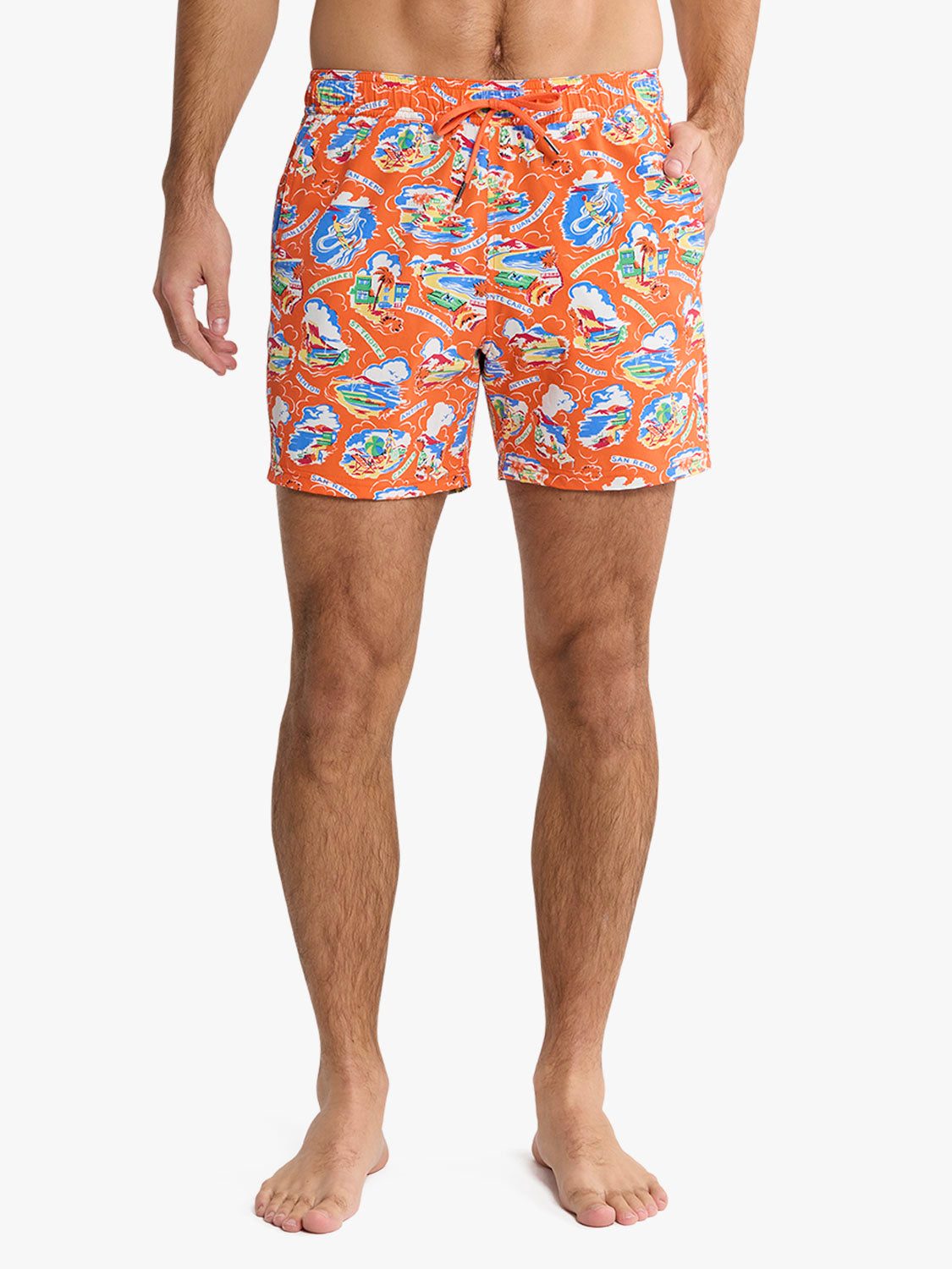 Man wearing orange swim trunks with blue and multicolored boat print pattern throughout.