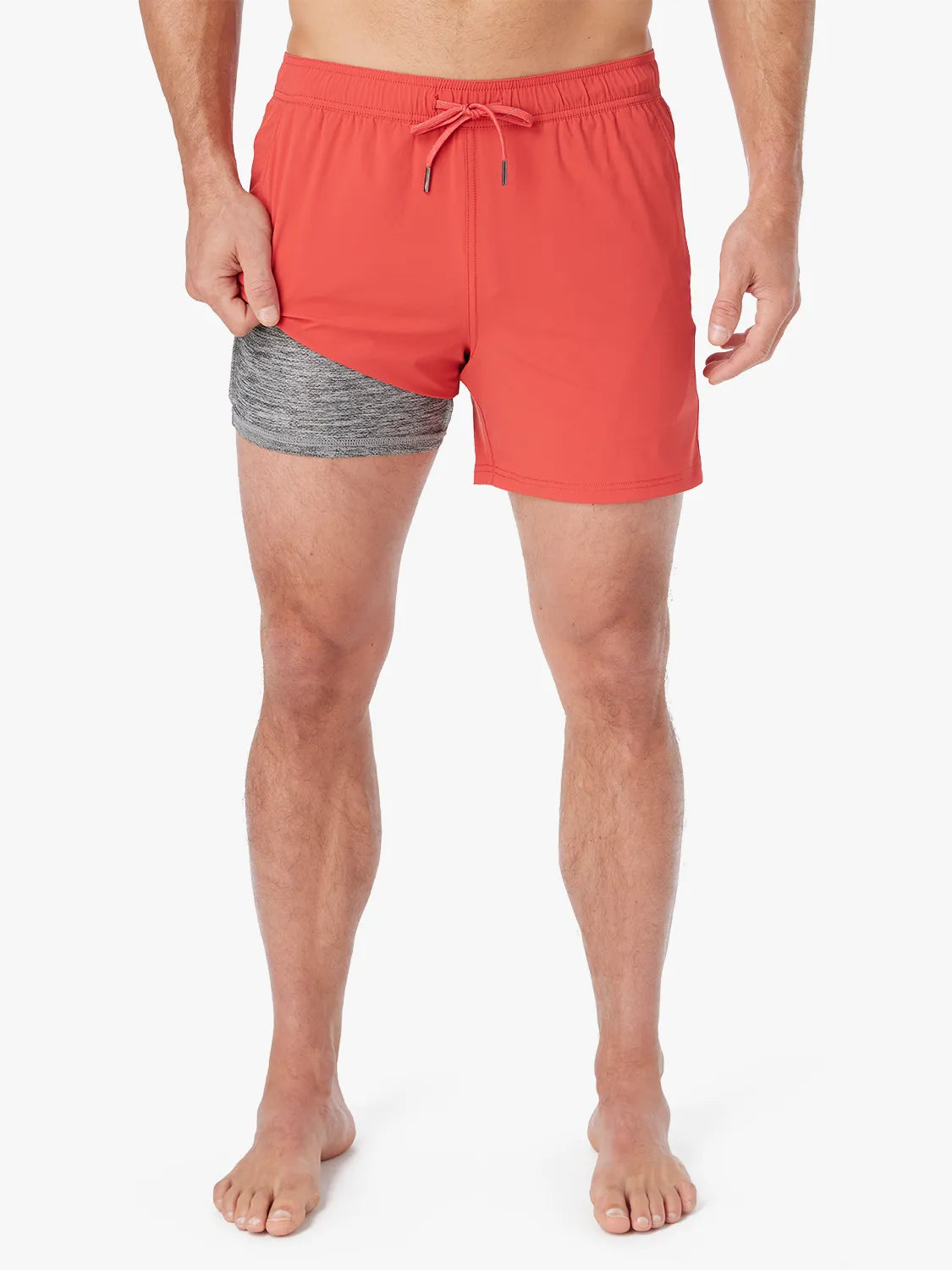Person wearing solid red bungalow trunk with drawstring on a white background. Showing the liner underneath.