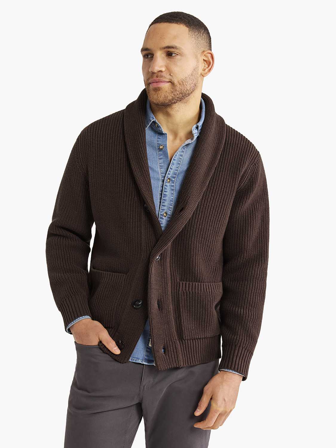 Man wearing a dark brown ribbed button-up cardigan sweater over a light blue denim shirt.