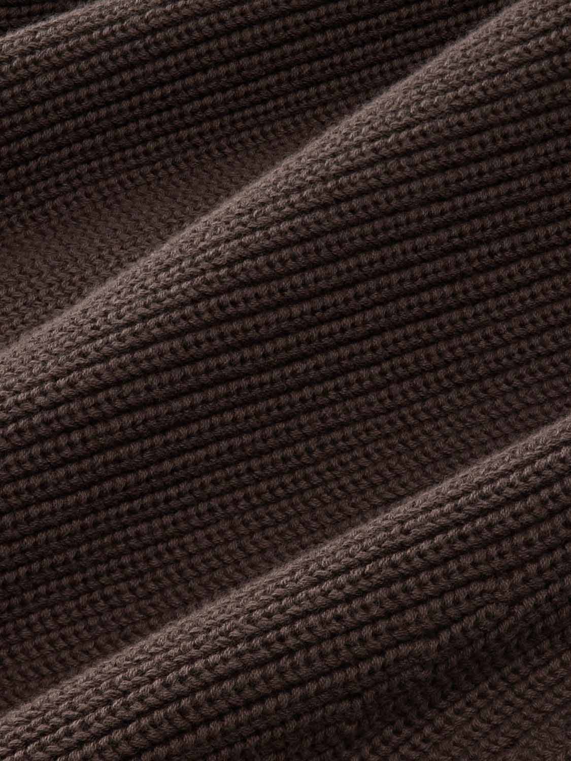 Dark brown ribbed knit sweater fabric with vertical texture patterns and folds.