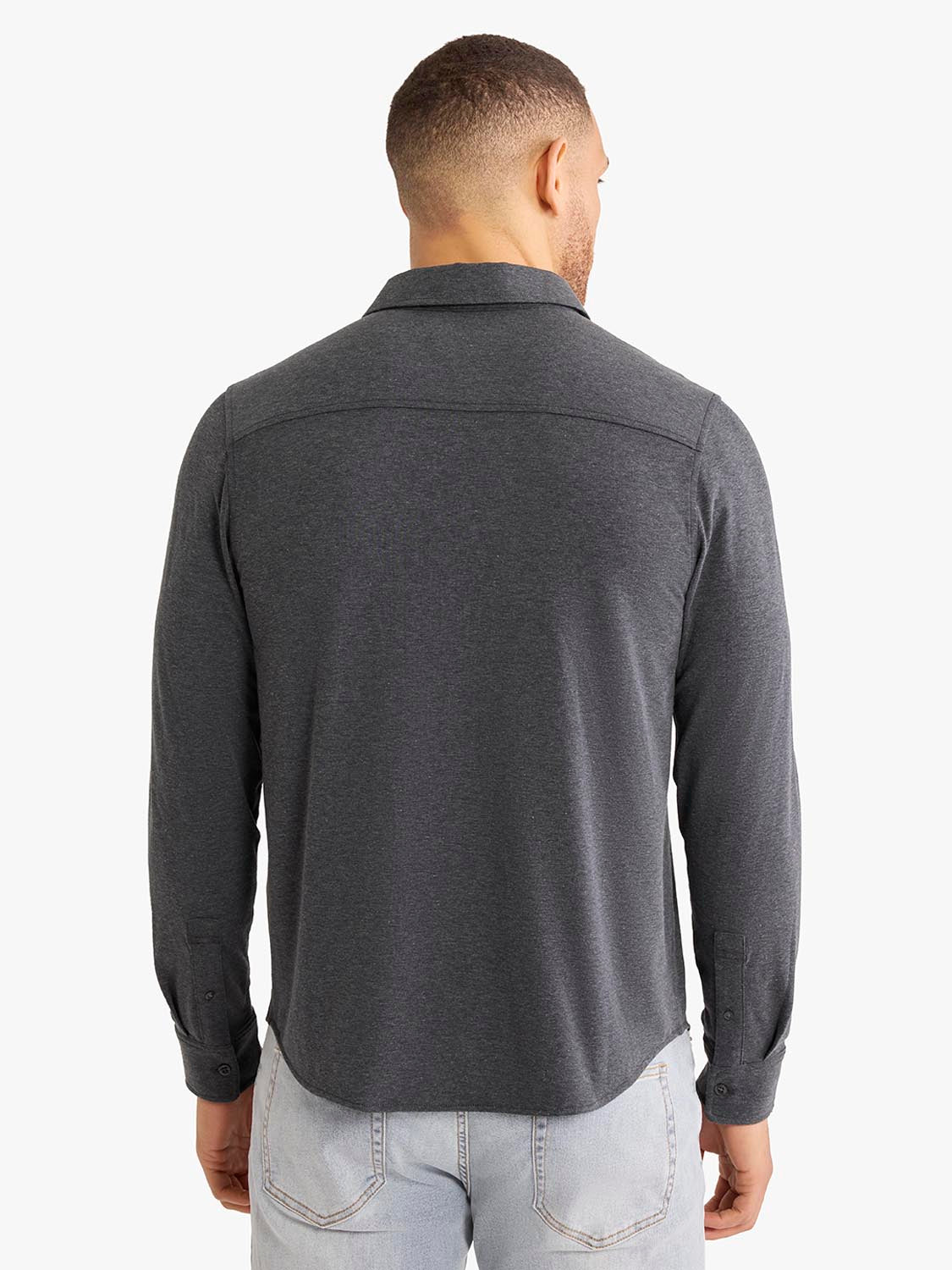 Man wearing a charcoal long sleeve button up shirt with collar, shown from the back.