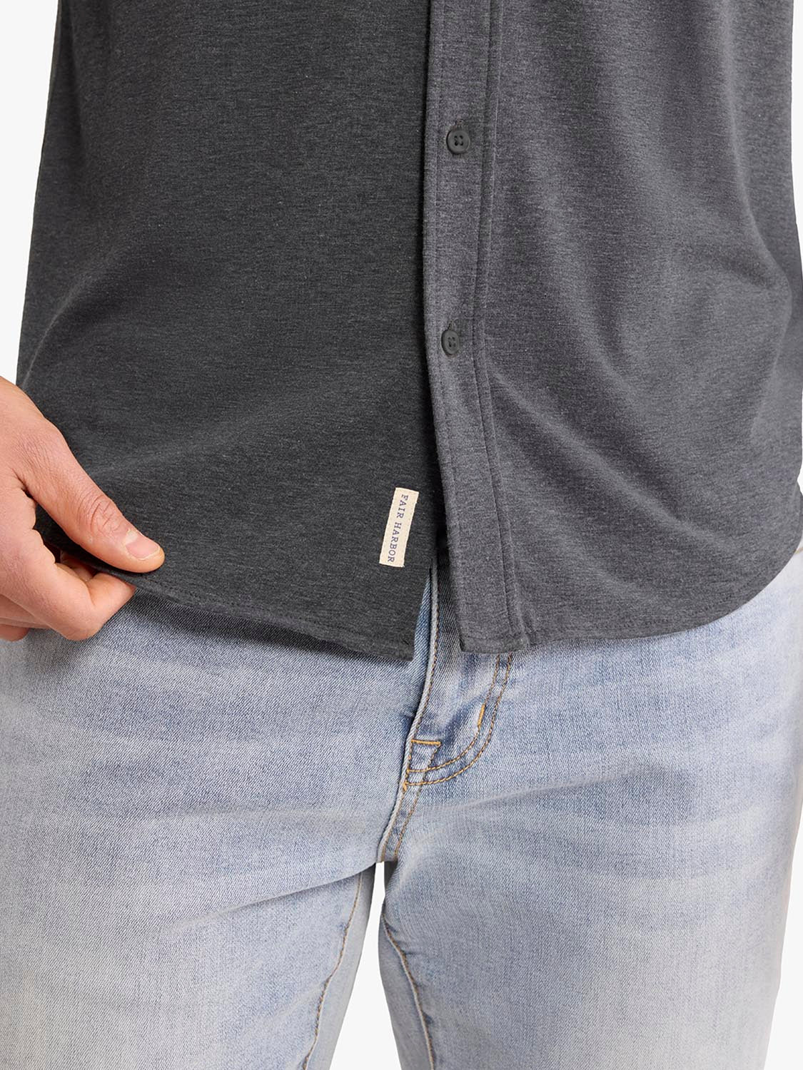 Charcoal long sleeve button-up shirt worn with light blue jeans, showing front placket and hem detail.