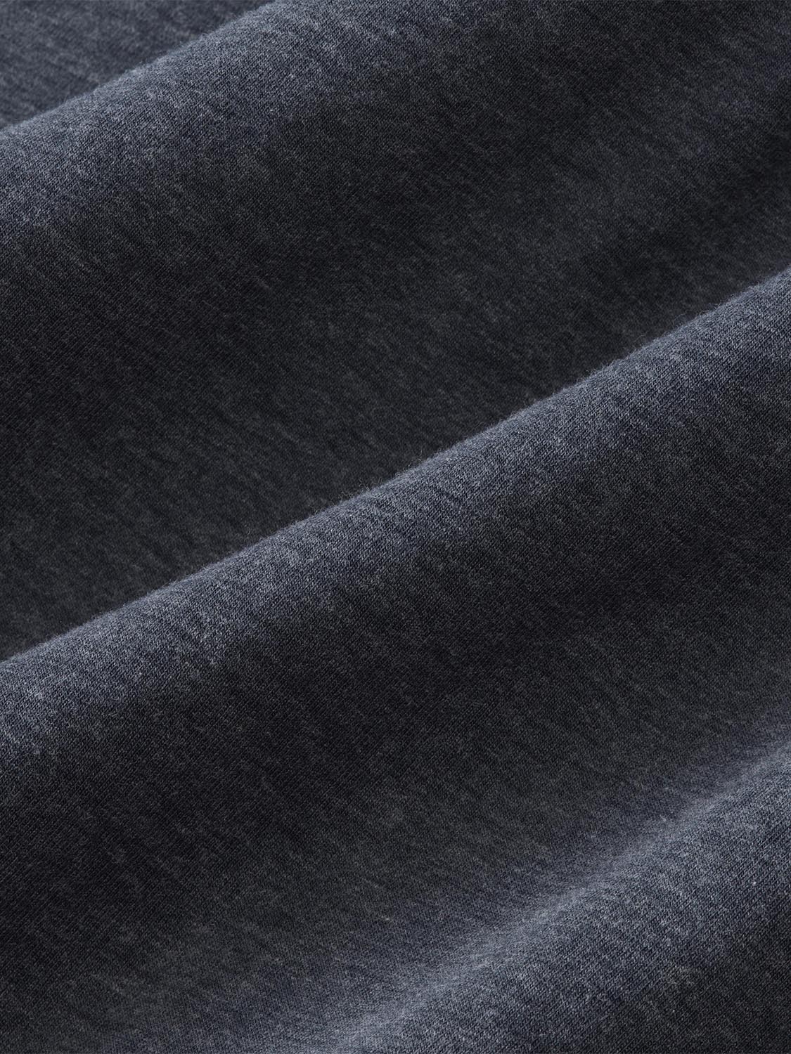 Charcoal colored fabric with textured weave and diagonal folds showing the material's depth and drape.