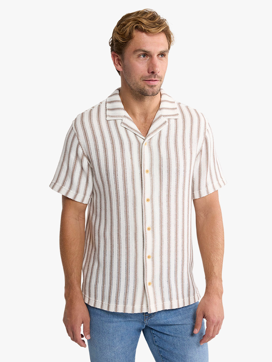 Man wearing a short-sleeve crochet shirt with vertical tan and cream stripes and mother-of-pearl buttons.