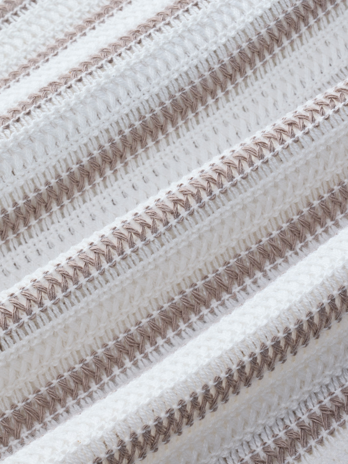 Crochet fabric with alternating tan and white vertical stripes and textured woven pattern.