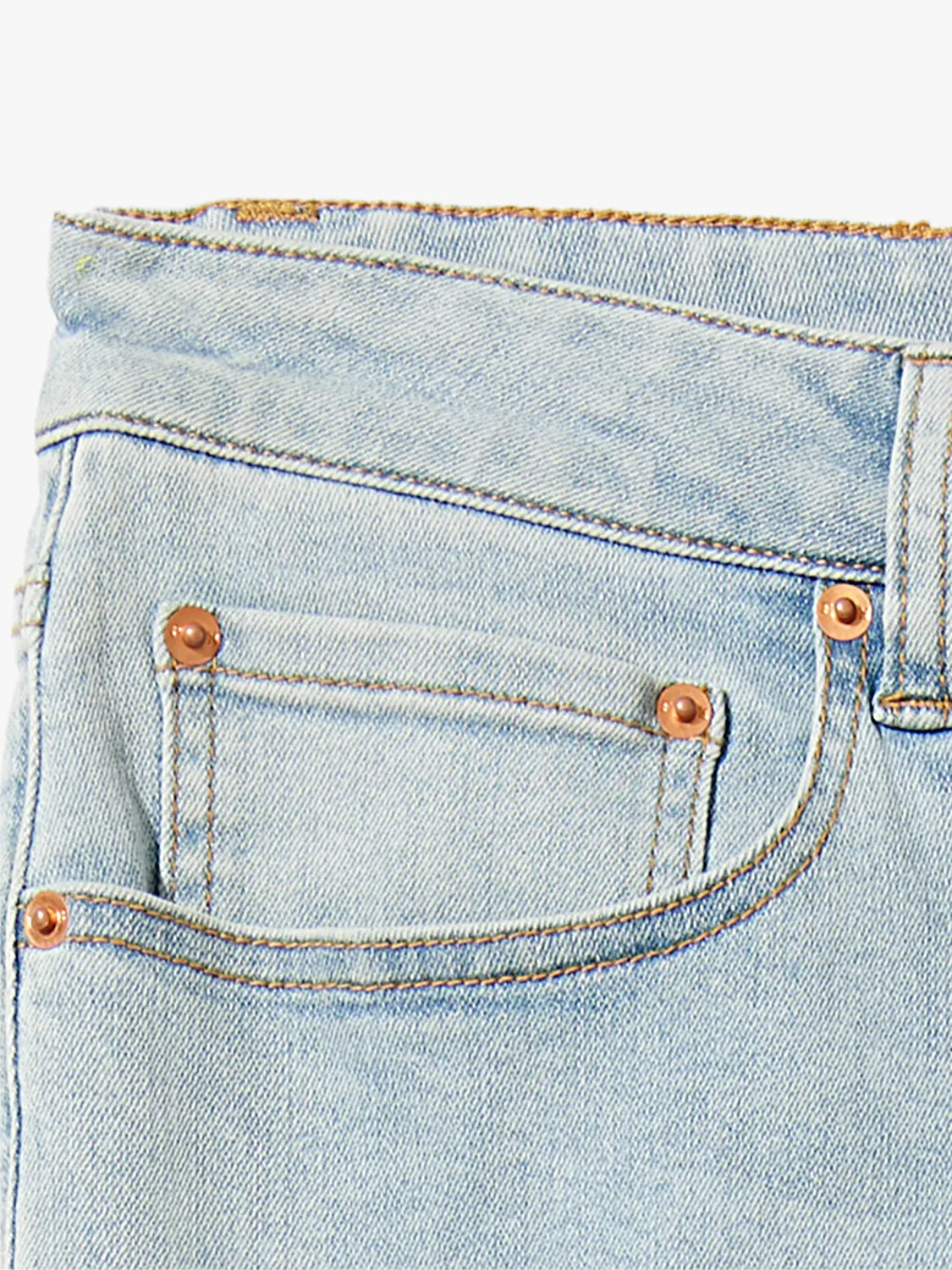 Detail image of the waist band and pocket design of pair of blue denim pants. 
