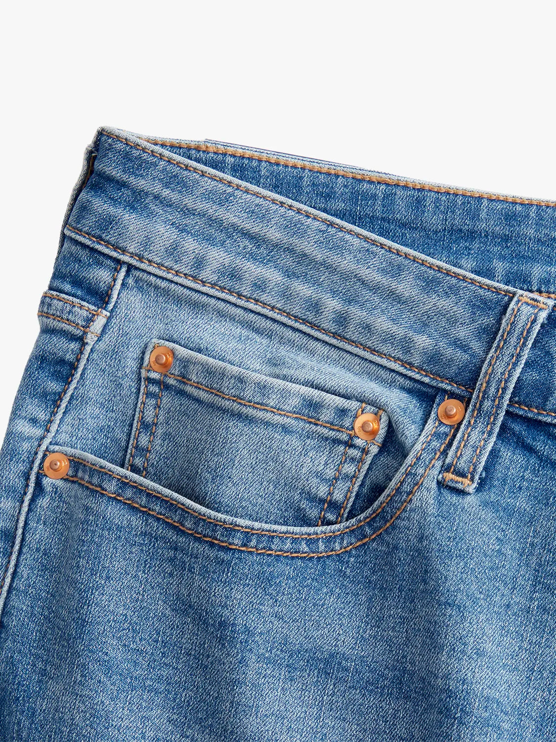 Detail image of the waist band and pocket design of pair of blue denim pants. 