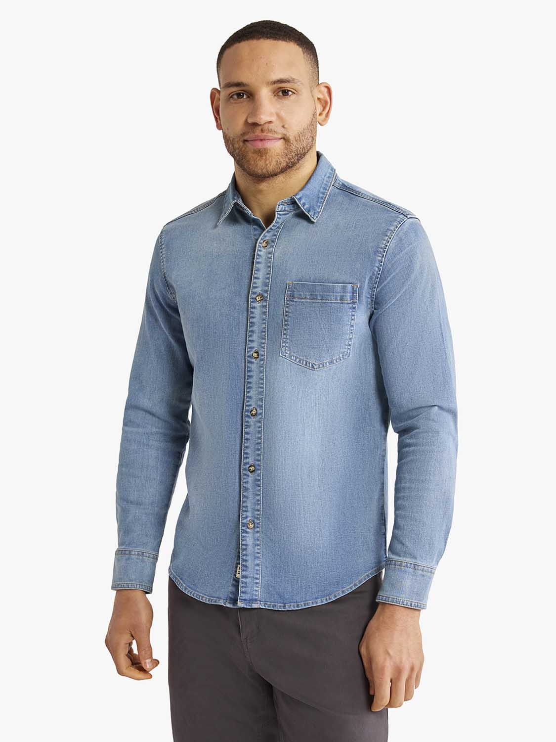 Man wearing a light blue denim shirt with button front and chest pocket.