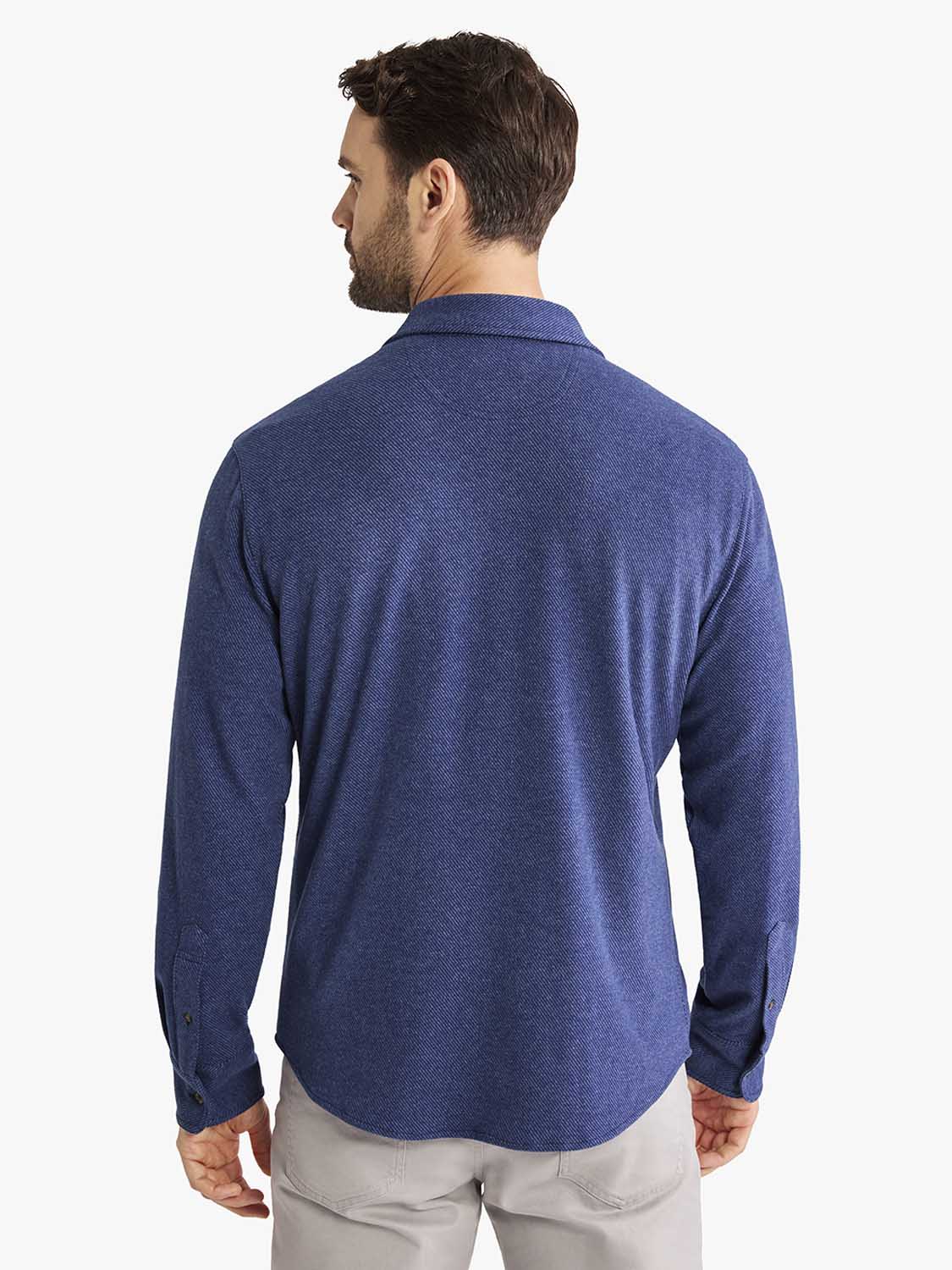Man wearing a navy blue flannel shirt with long sleeves and a collar, shown from the back.
