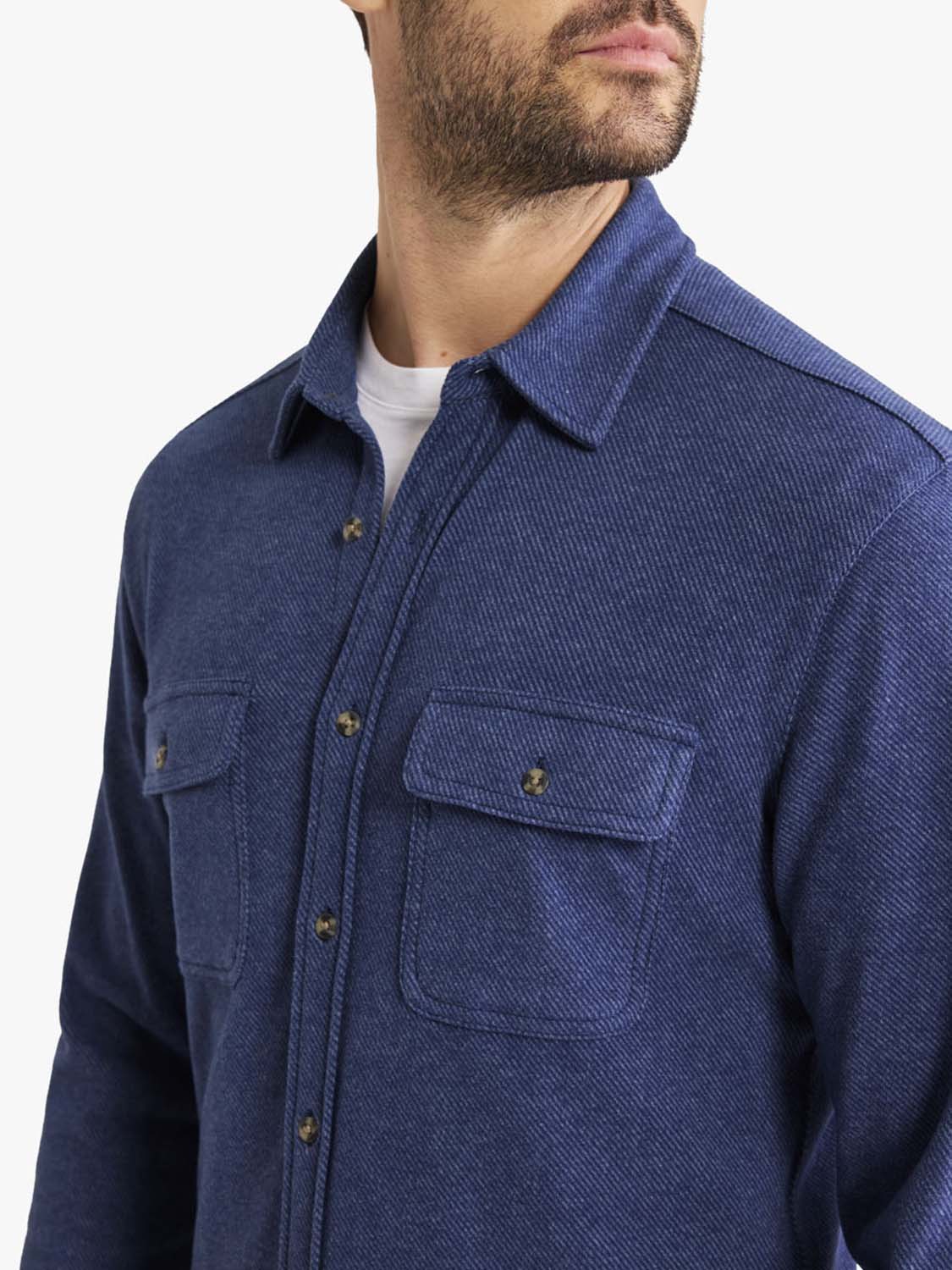 Man wearing a navy blue flannel shirt with button front, collar, and chest pockets.