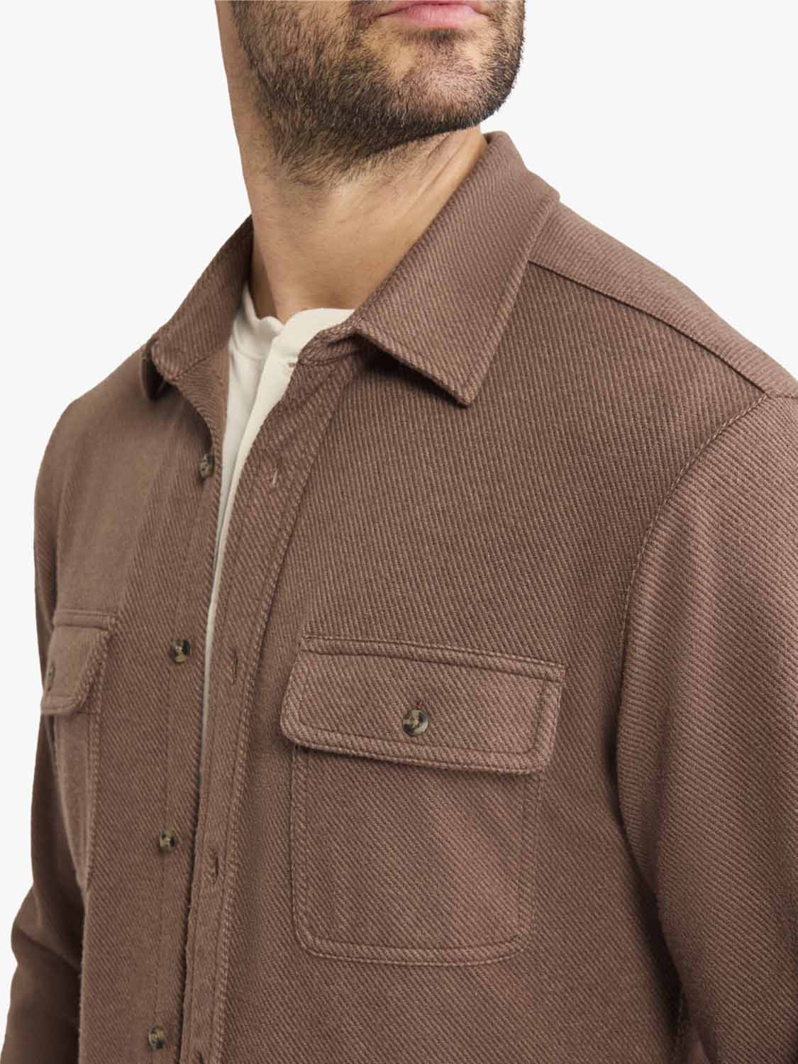 Man wearing a brown espresso twill flannel shirt with chest pockets and button front closure.