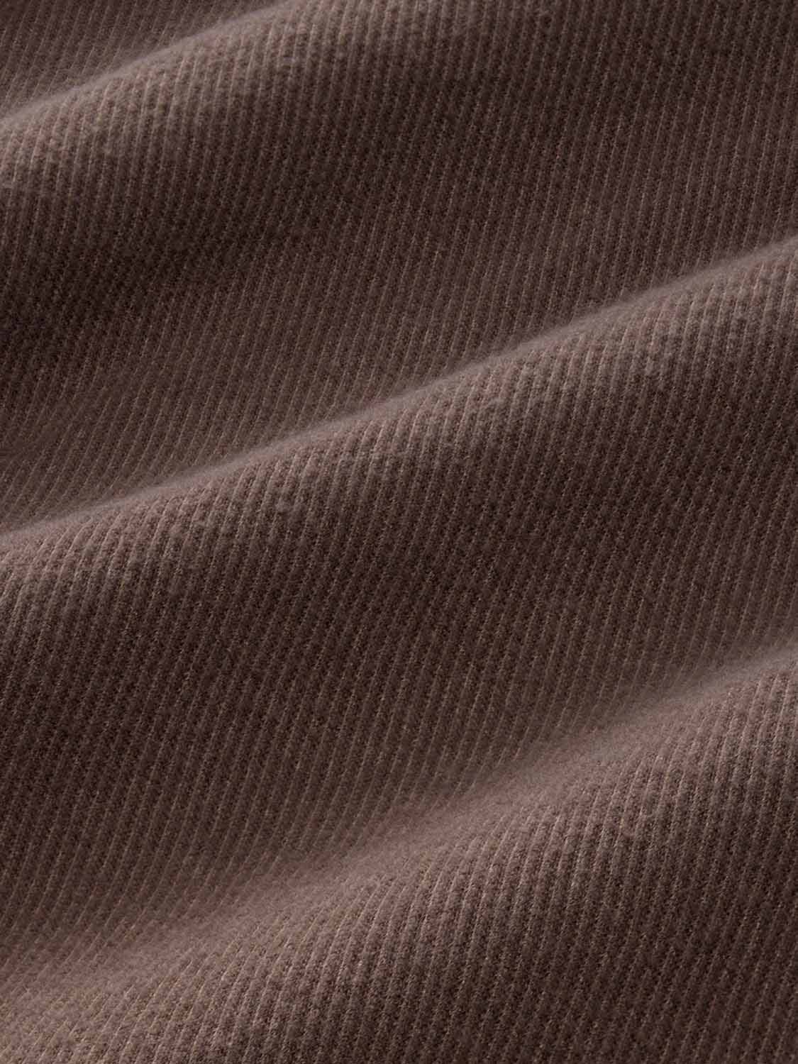 Close-up of espresso brown twill fabric with diagonal ribbed texture and soft folds.