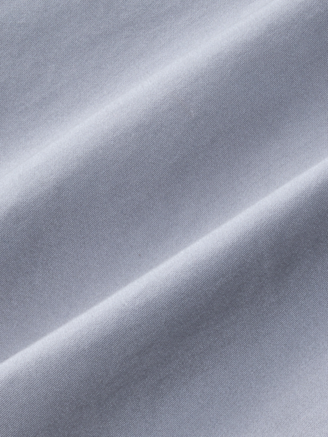Close-up of light gray textured fabric with diagonal ribbed weave and natural highlighting.