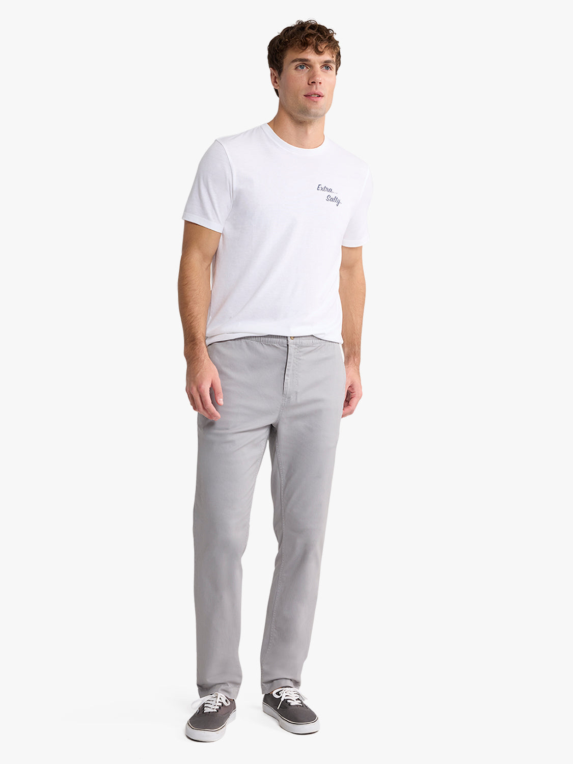 Man wearing a white t-shirt and light gray pull-on pants with sneakers.