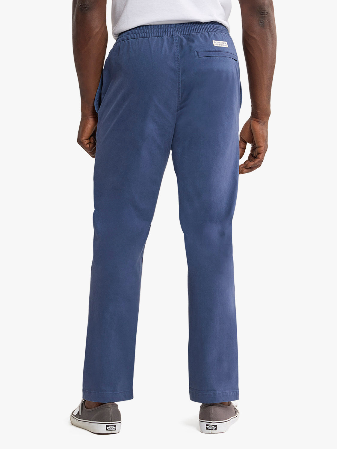 Man wearing navy blue pull-on pants with elastic waistband viewed from the back.