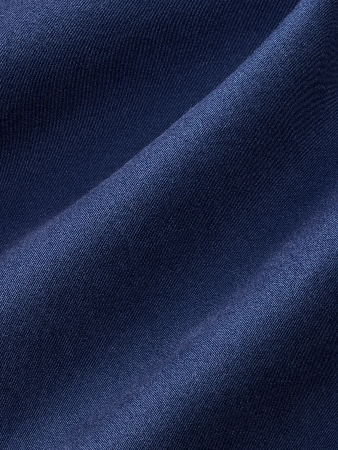 Navy blue fabric with a textured diagonal fold creating contrasting light and shadow areas.