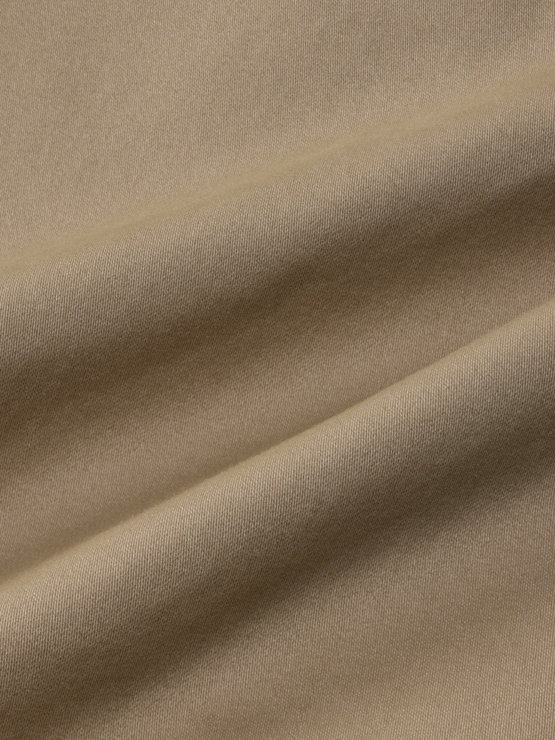 Khaki colored fabric with a ribbed texture and natural folds throughout the material.