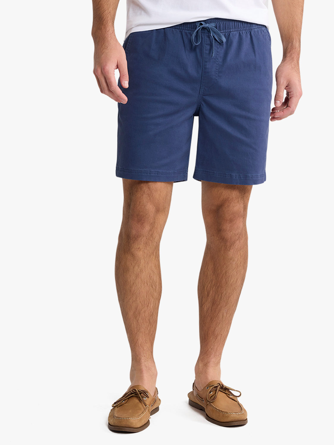 Man wearing navy blue pull-on shorts with drawstring waist and tan boat shoes.