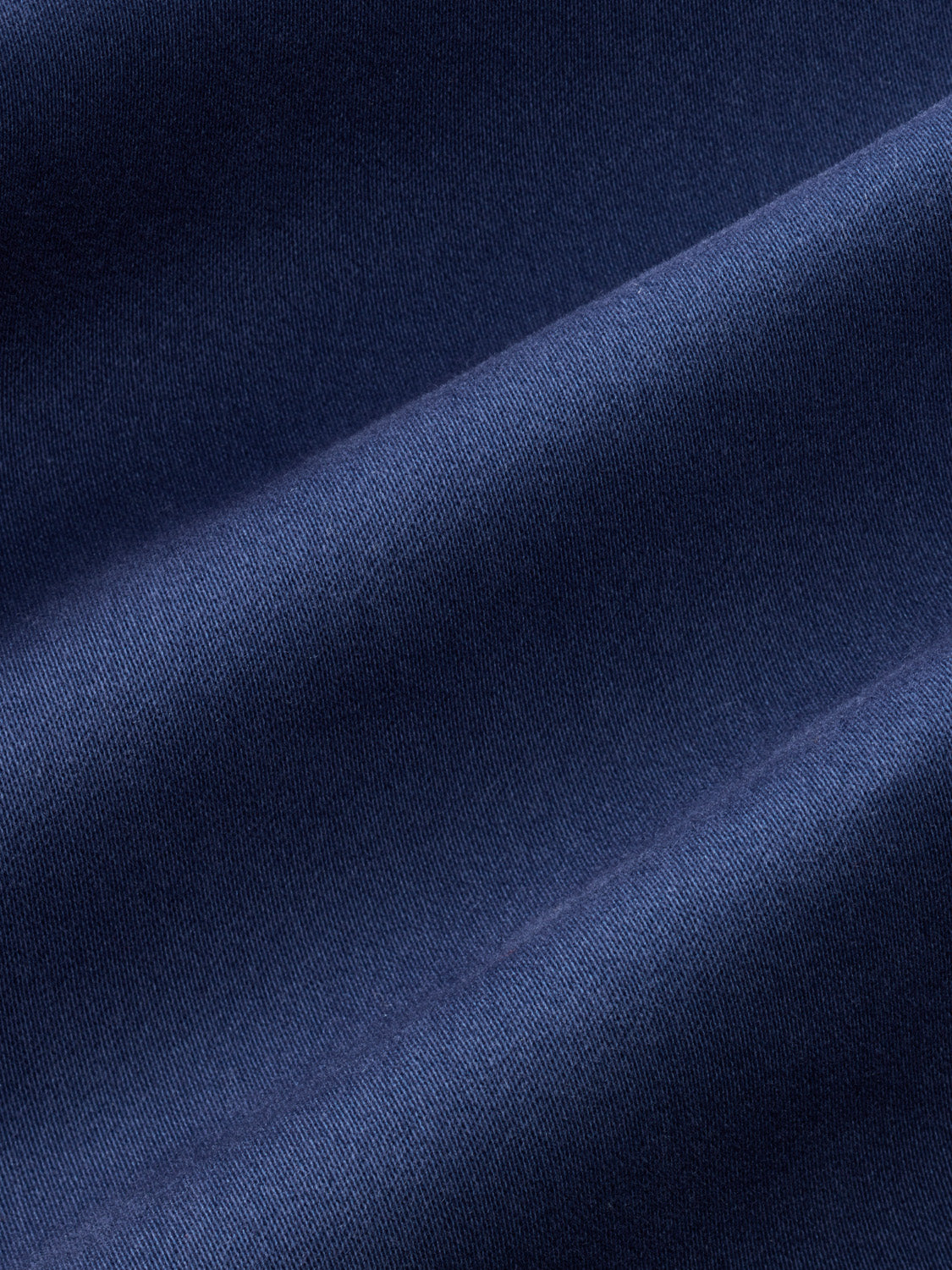 Close-up view of navy ribbed fabric with diagonal folds and textured surface detail.