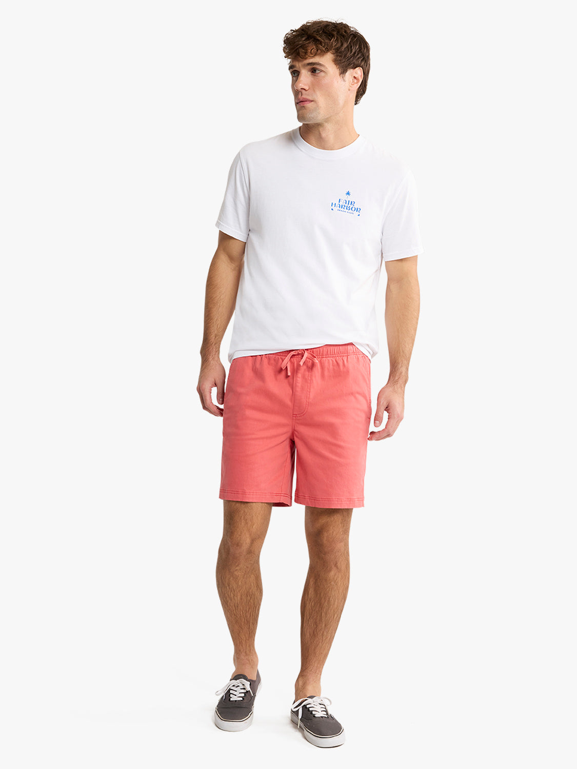 Man wearing white t-shirt and washed red pull-on shorts with drawstring waist and sneakers.