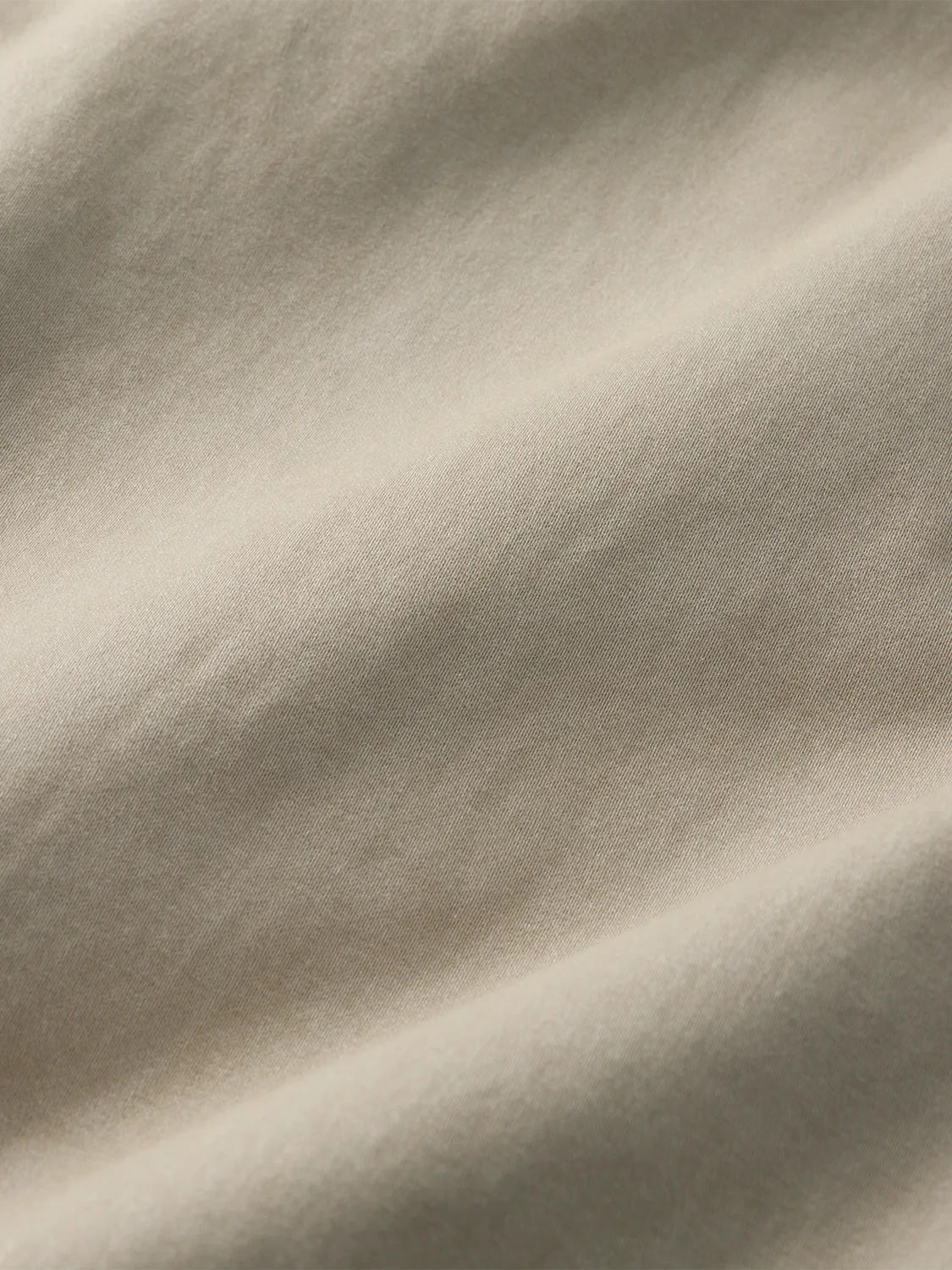 Close-up of khaki cotton twill fabric showing diagonal weave pattern and soft texture.