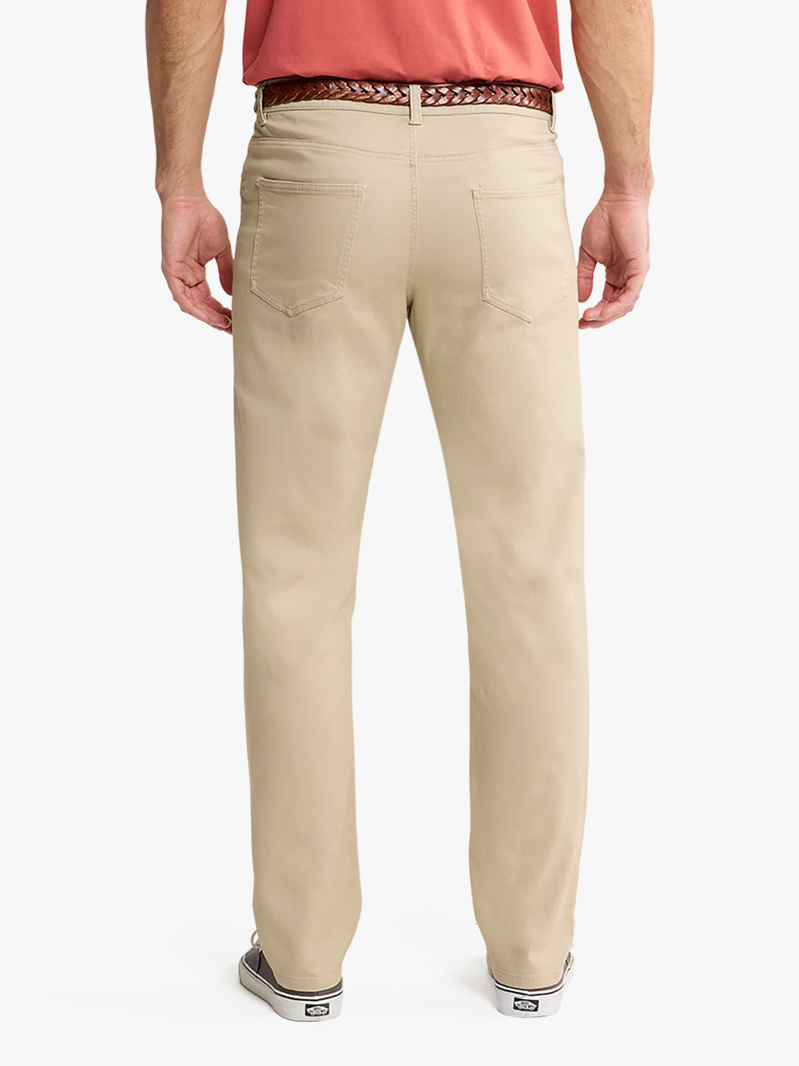 Man wearing khaki five-pocket pants with back pockets visible and woven belt detail.