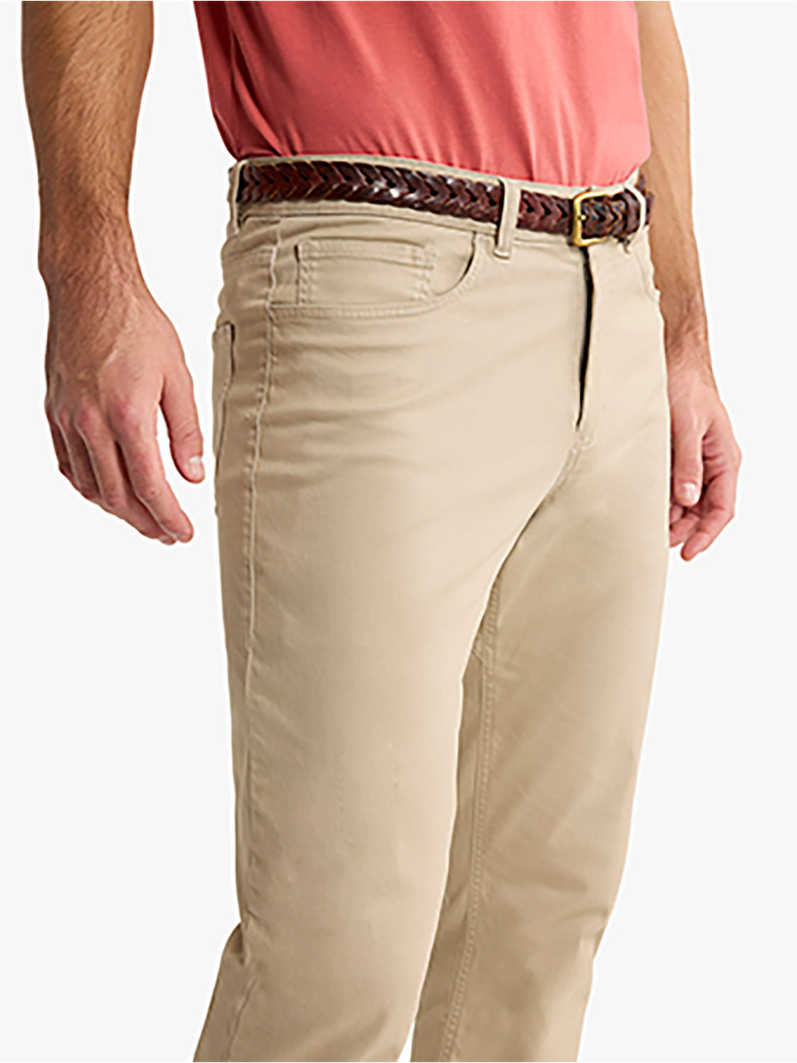 Man wearing khaki five-pocket pants with a braided leather belt and pink shirt.