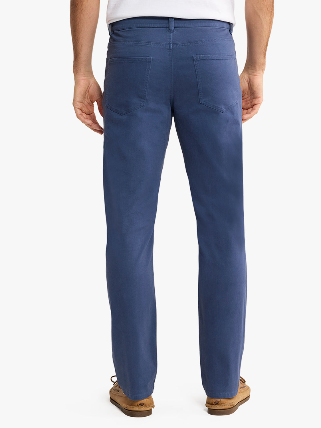 Man wearing navy blue five-pocket pants with back pockets visible from behind.