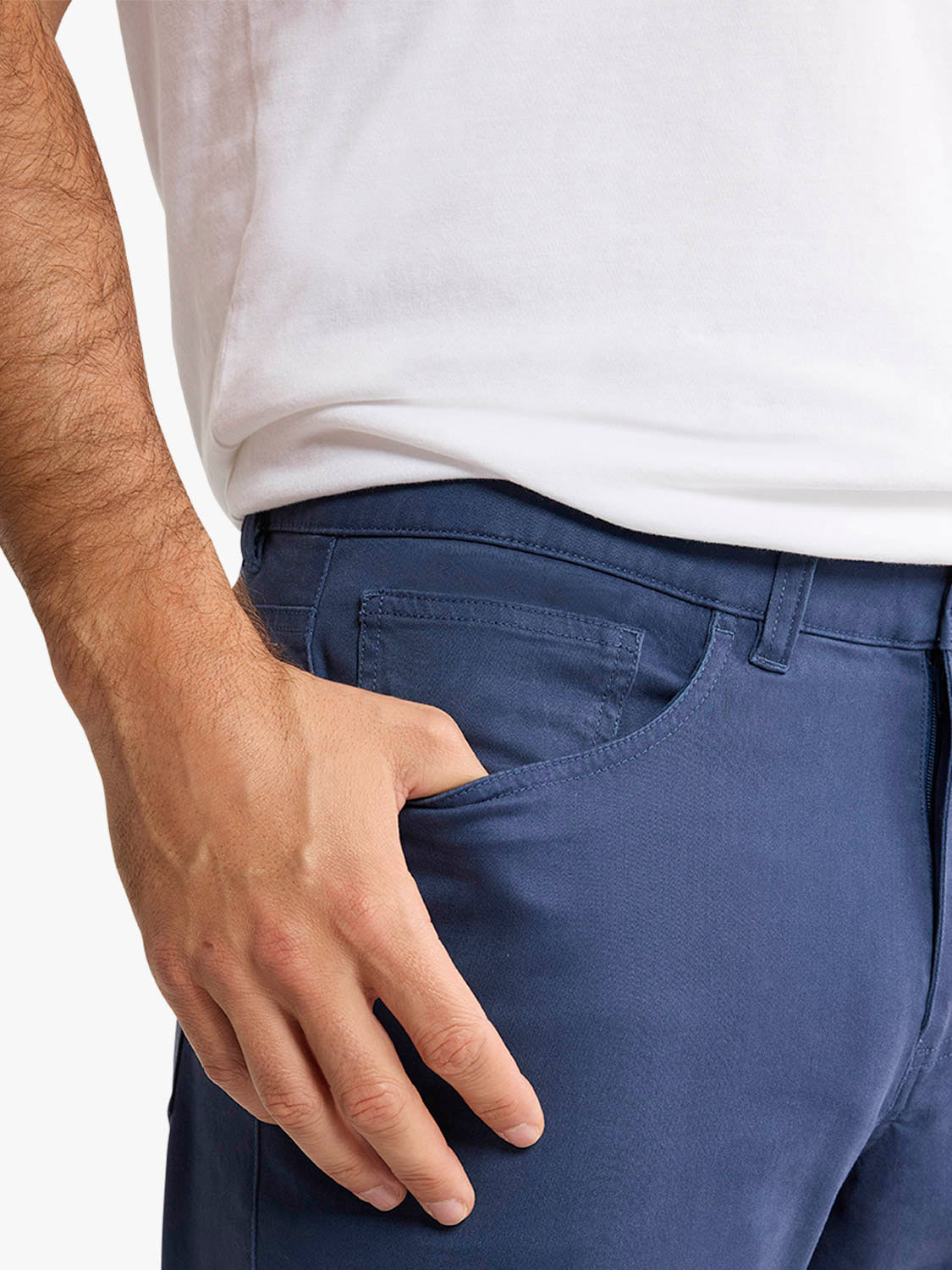 Man wearing navy five-pocket pants with white shirt, showing front pocket detail and fit.