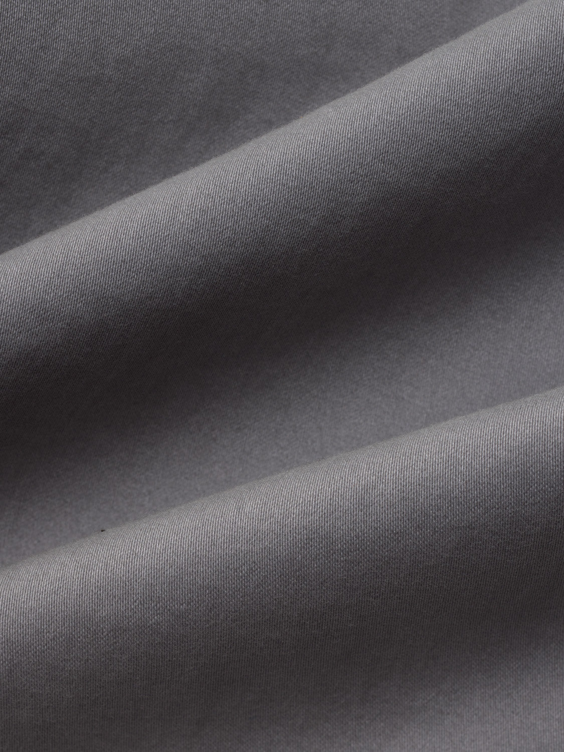 Close-up of seastone-colored fabric with a ribbed texture and diagonal folds.