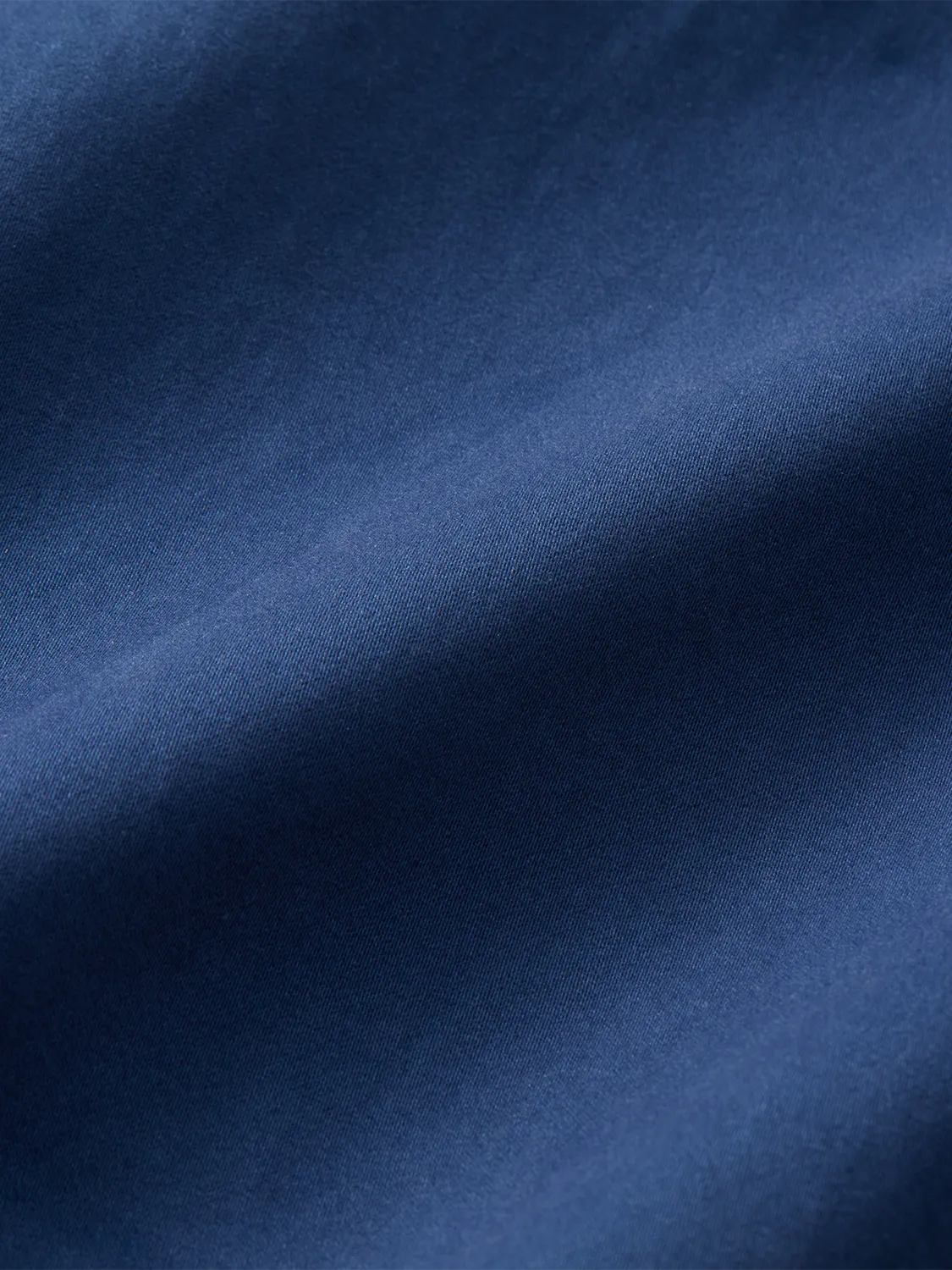 Close-up of navy blue woven fabric with a diagonal twill texture and subtle sheen.