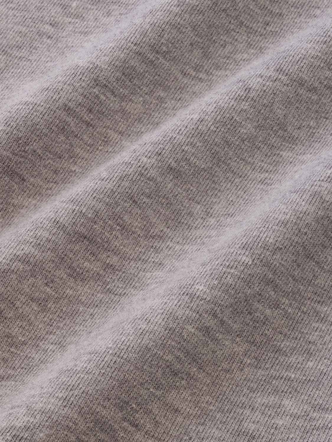 Heather grey t-shirt fabric with ribbed texture and diagonal fold lines visible throughout.
