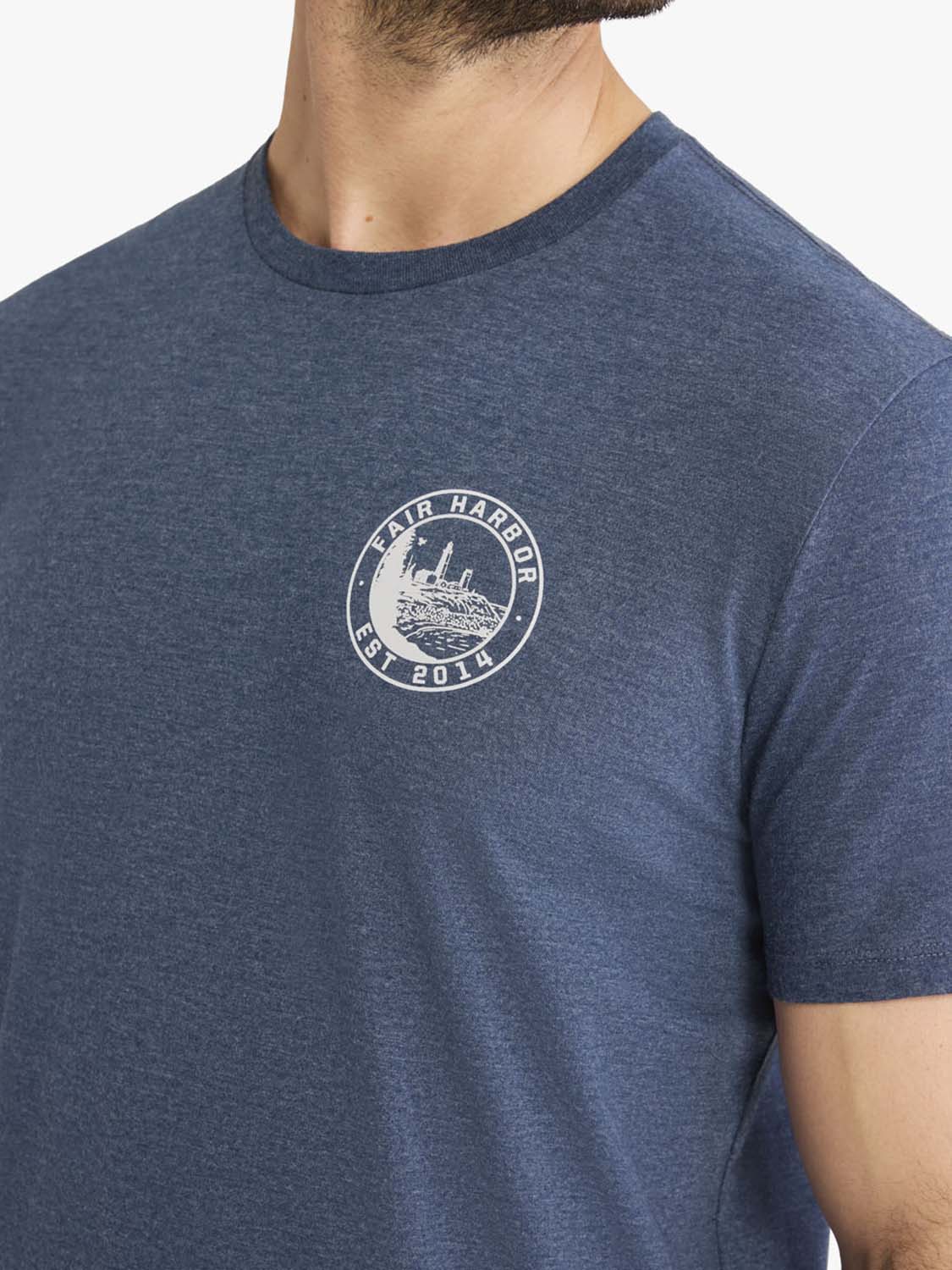 Heather blue t-shirt with a circular lighthouse stamp graphic printed on the chest.
