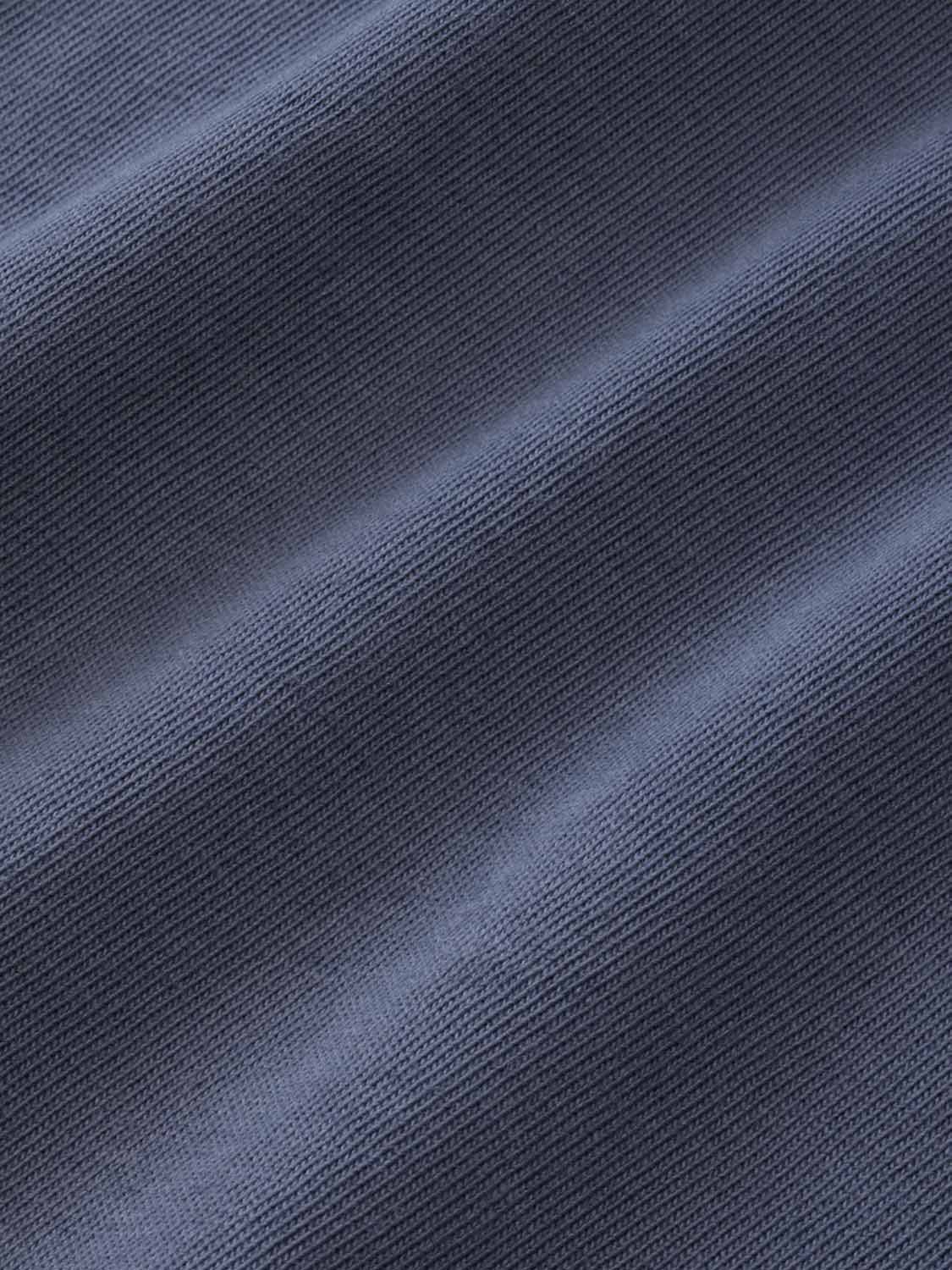 Blue-gray textured fabric with diagonal ribbed pattern and natural folds throughout.