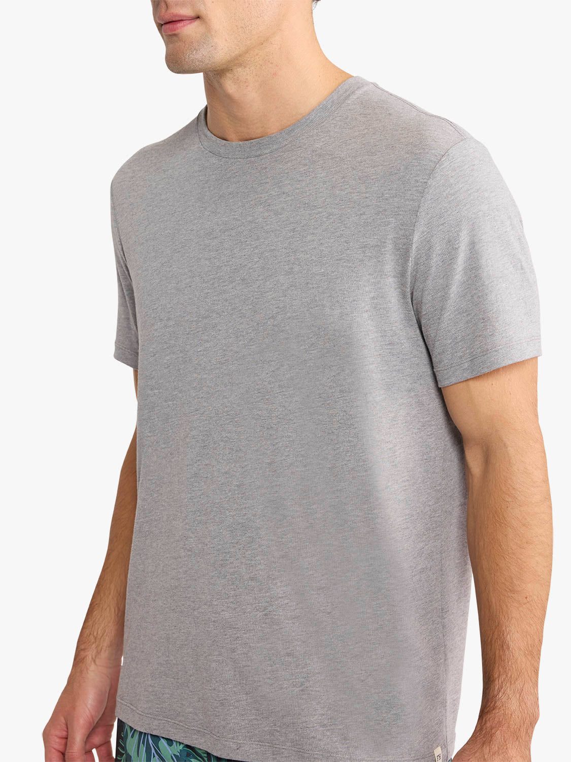 Man wearing a heather grey short-sleeve crew neck t-shirt displayed in a side profile view.