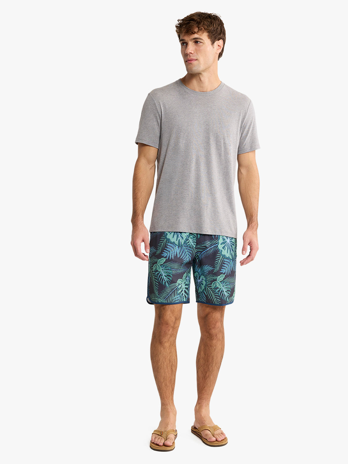 Man wearing a heather grey short-sleeve crew neck t-shirt with patterned shorts and sandals.