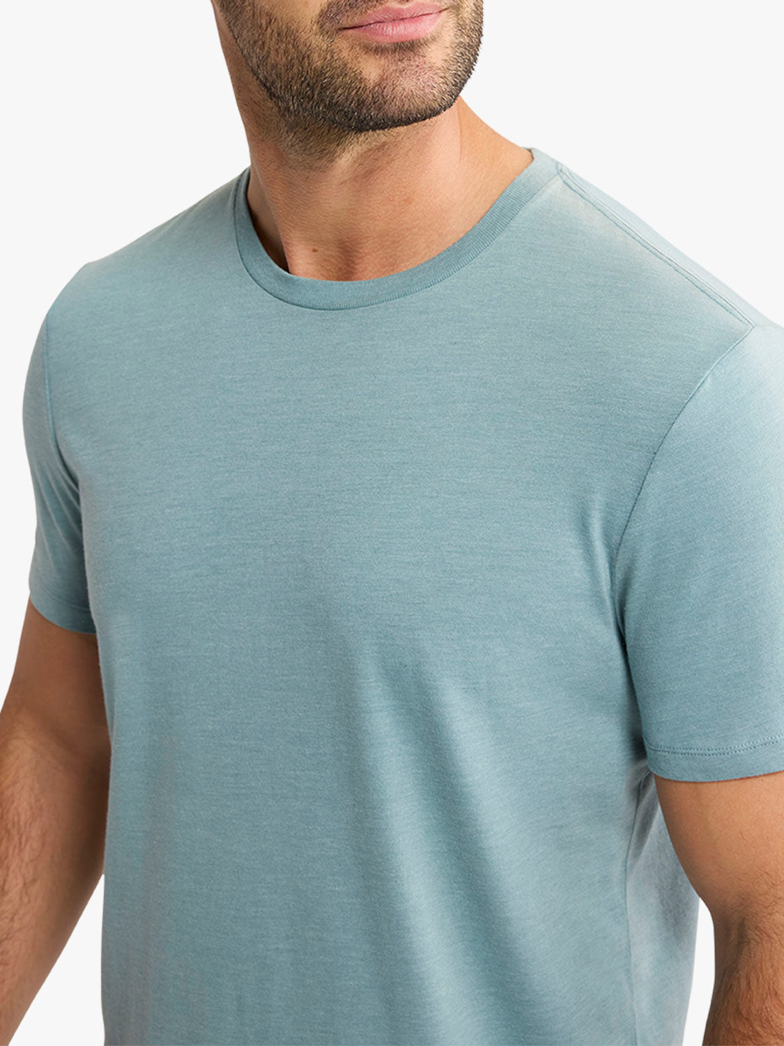 Man wearing a heather green crew neck t-shirt with short sleeves and a relaxed fit.