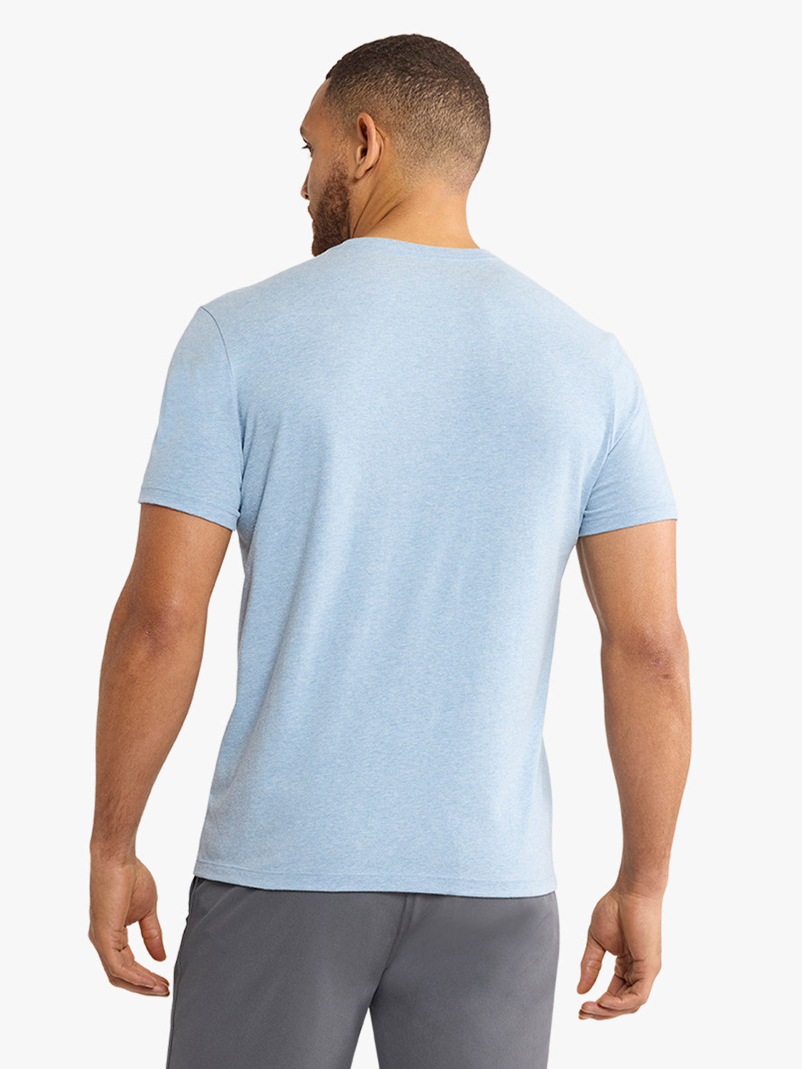 Man wearing a faded denim blue short-sleeve t-shirt, shown from the back view.
