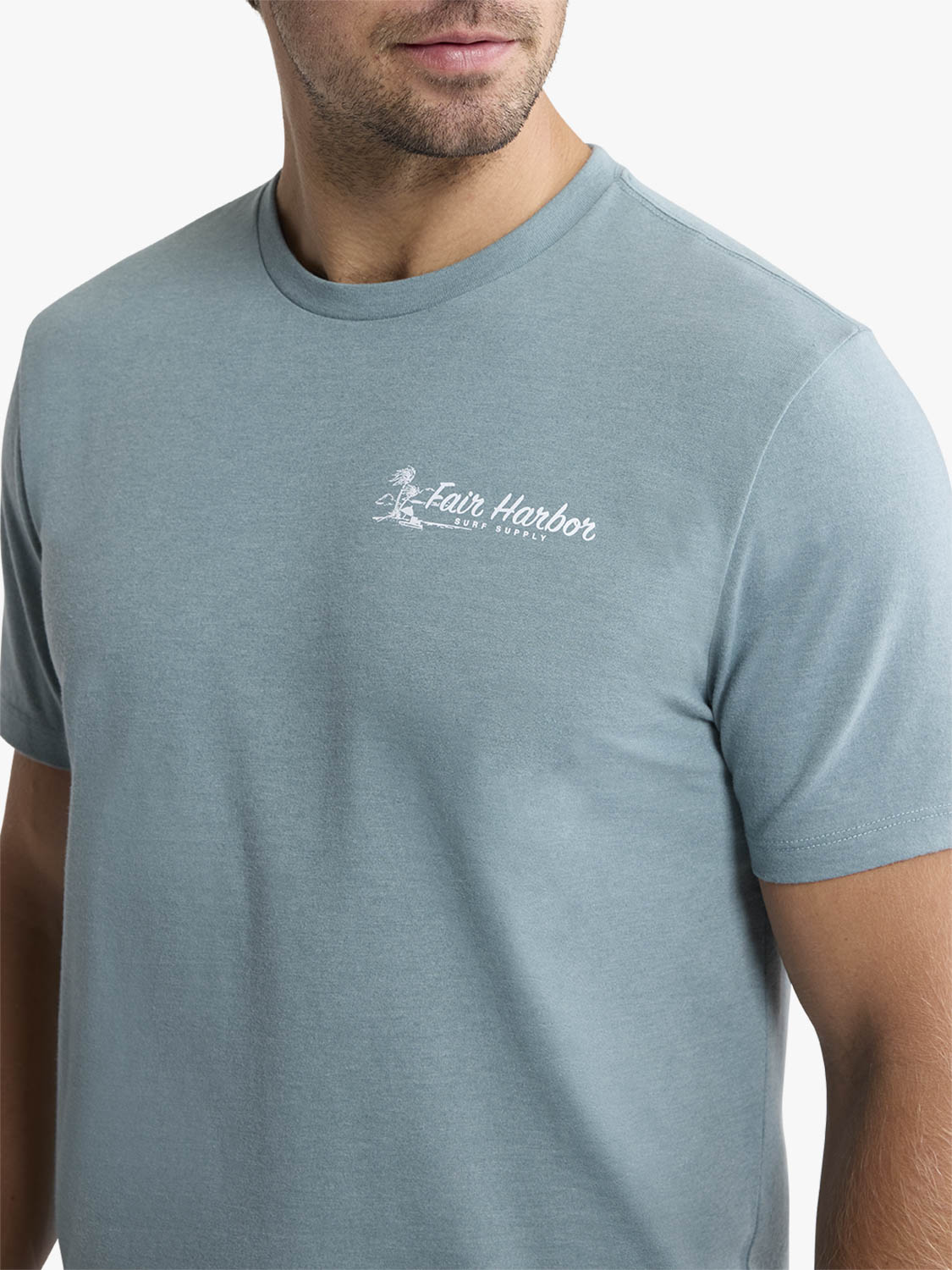 Man wearing a dusty blue short-sleeve t-shirt with white 