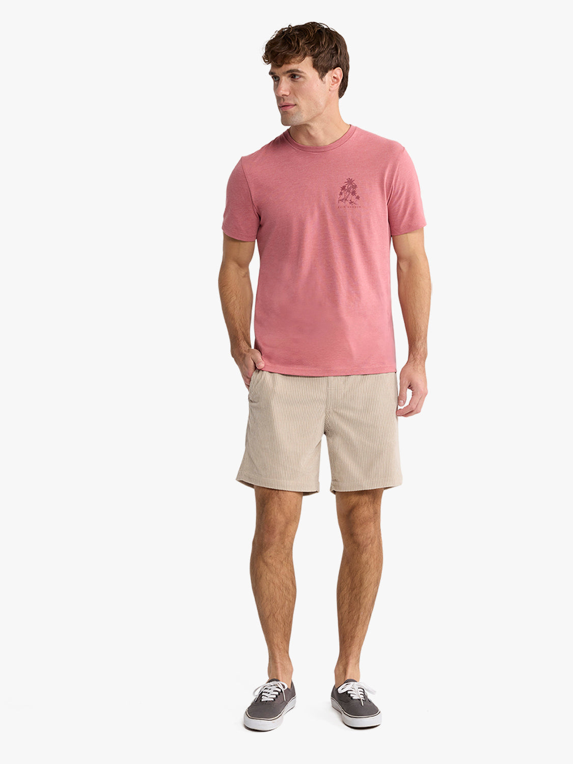 Man wearing a pink graphic tee with a small palm tree design on the chest.