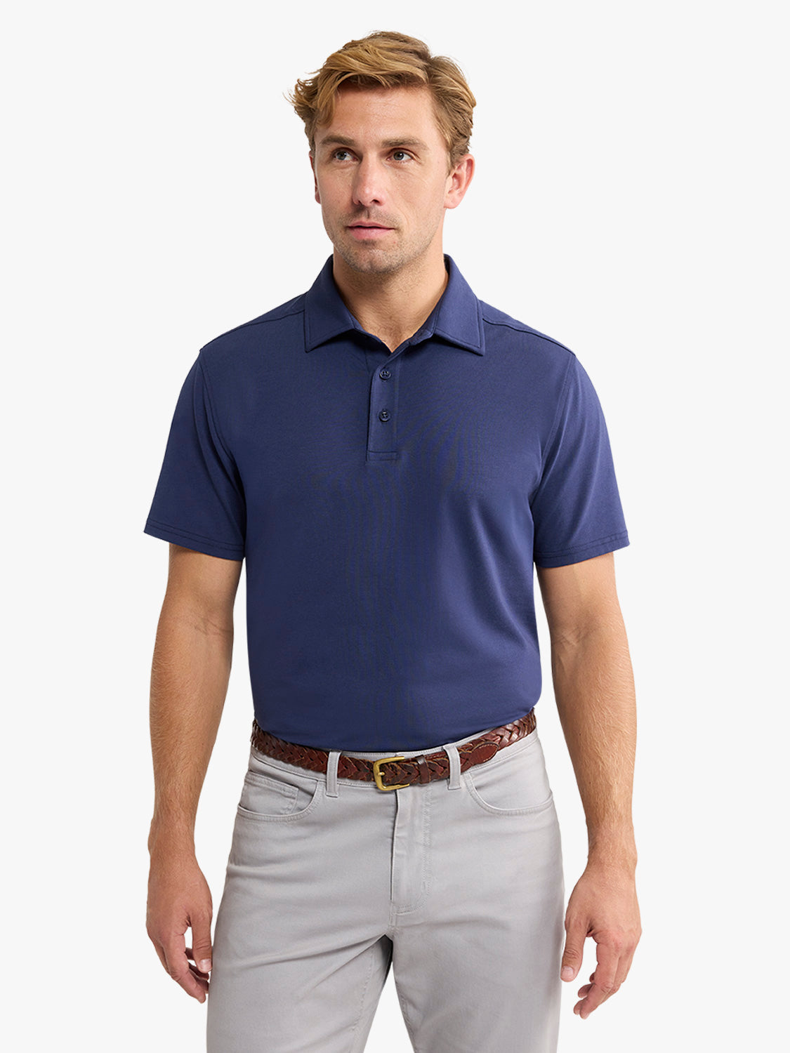 Man wearing navy short-sleeve polo shirt with collar and buttons, paired with light gray pants and brown belt.