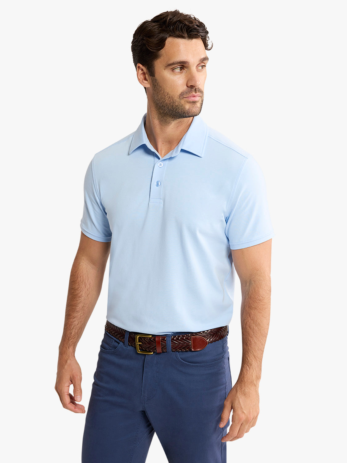 Man wearing a light blue short-sleeve polo shirt with navy pants and a woven belt.