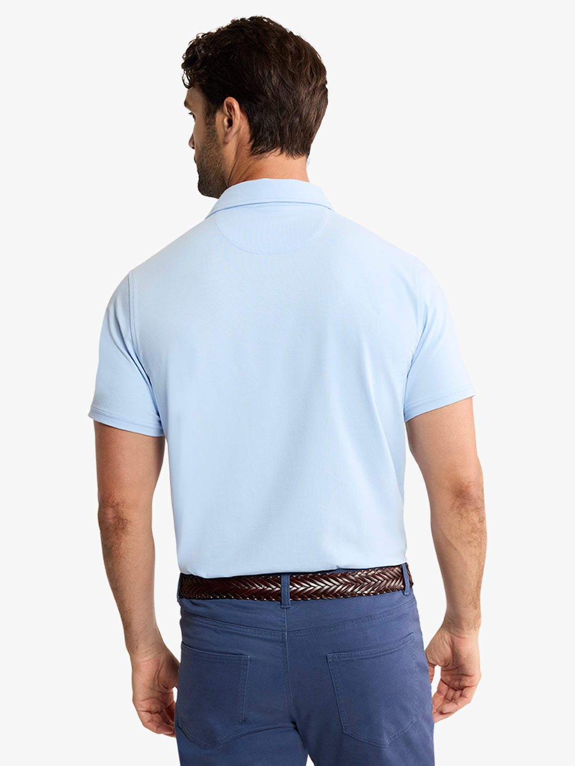Man wearing light blue polo shirt with collared neckline and short sleeves shown from back view.