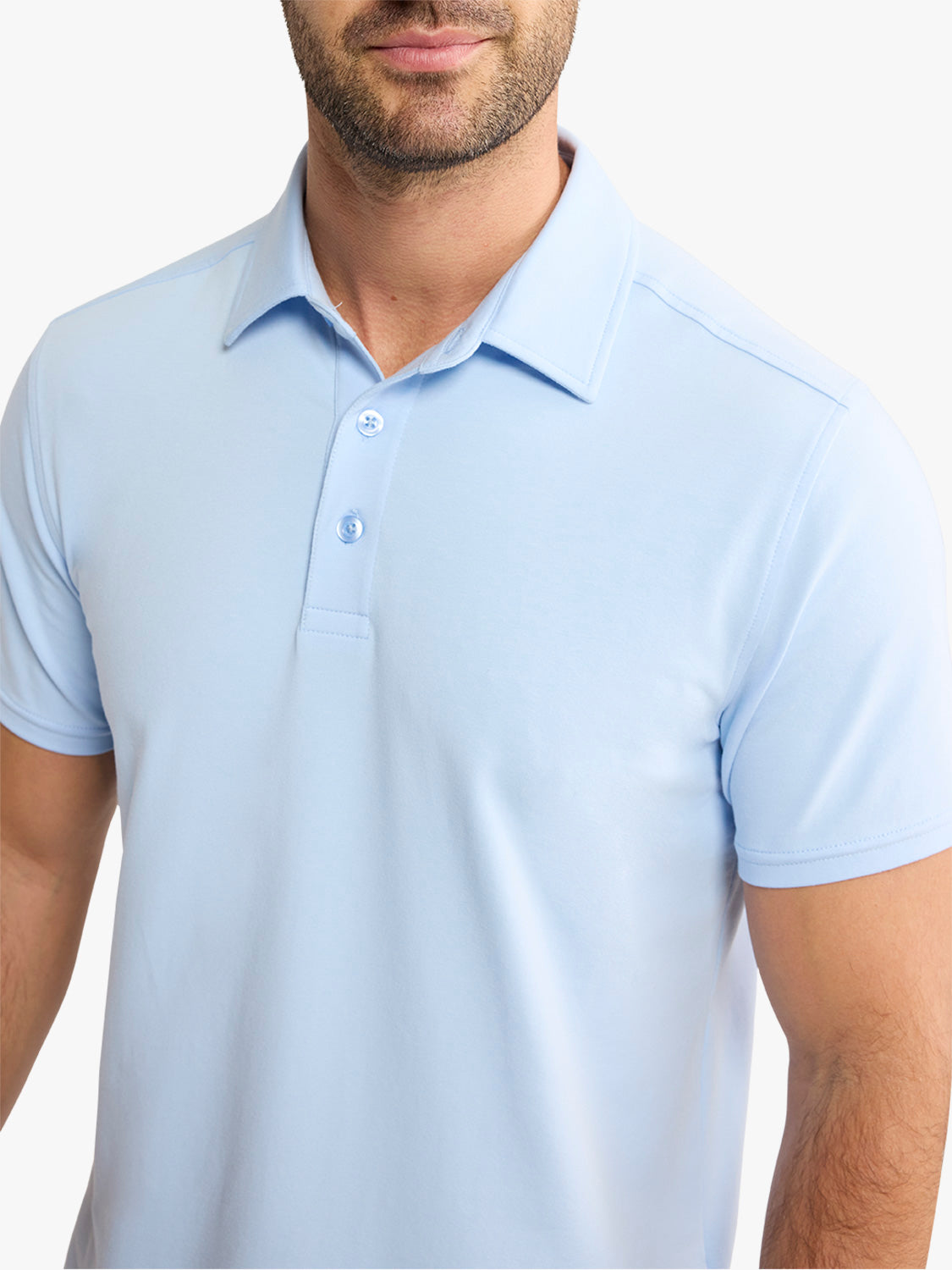 Man wearing a light blue polo shirt with short sleeves and button placket.