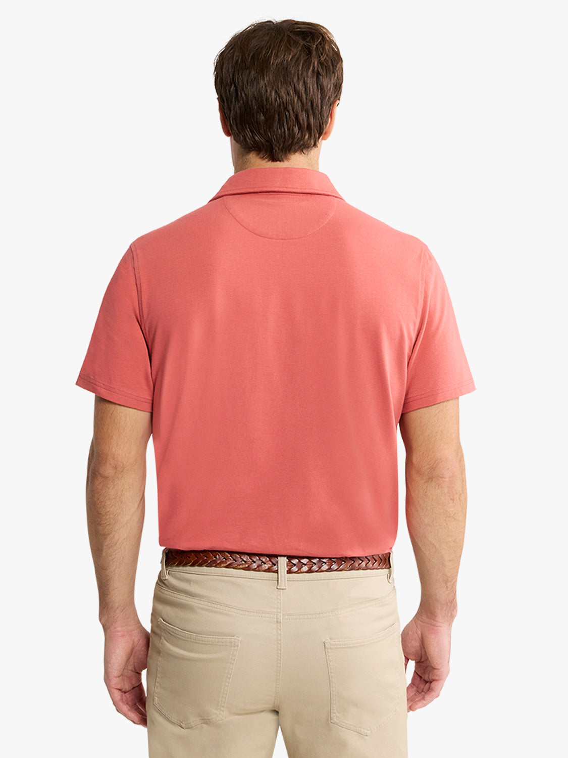 Man wearing a red polo shirt with a collar and beige pants, shown from behind.