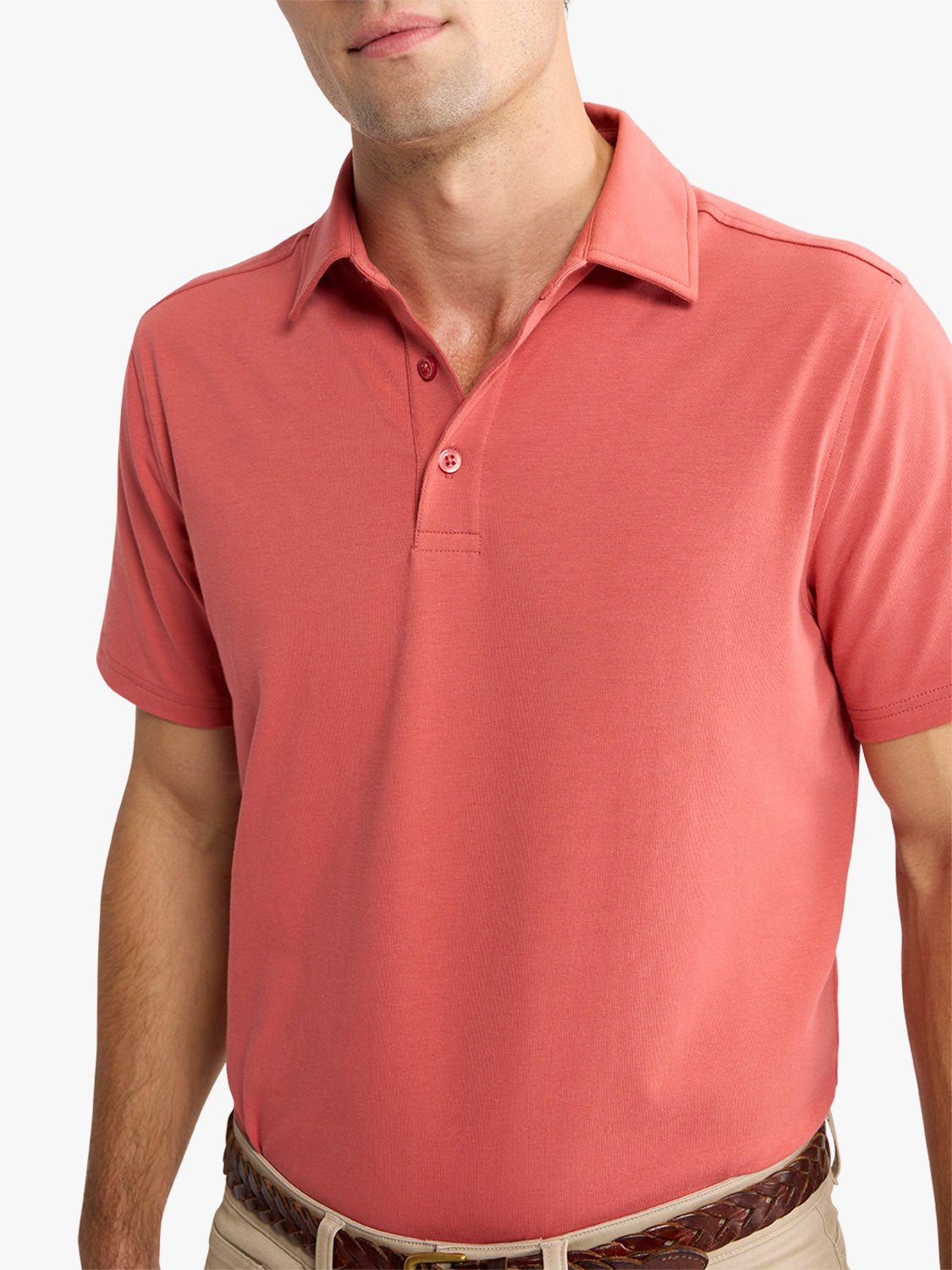 Man wearing a red polo shirt with short sleeves and button placket detail.