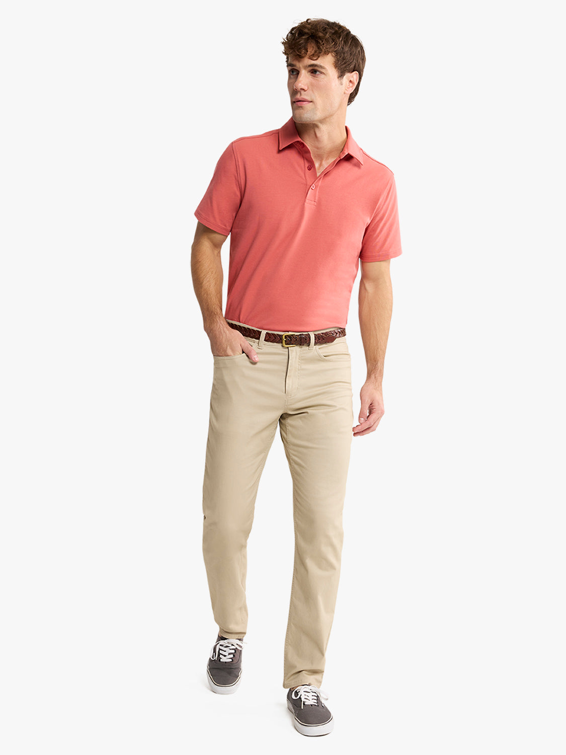 Man wearing a red polo shirt with khaki pants and a brown belt.