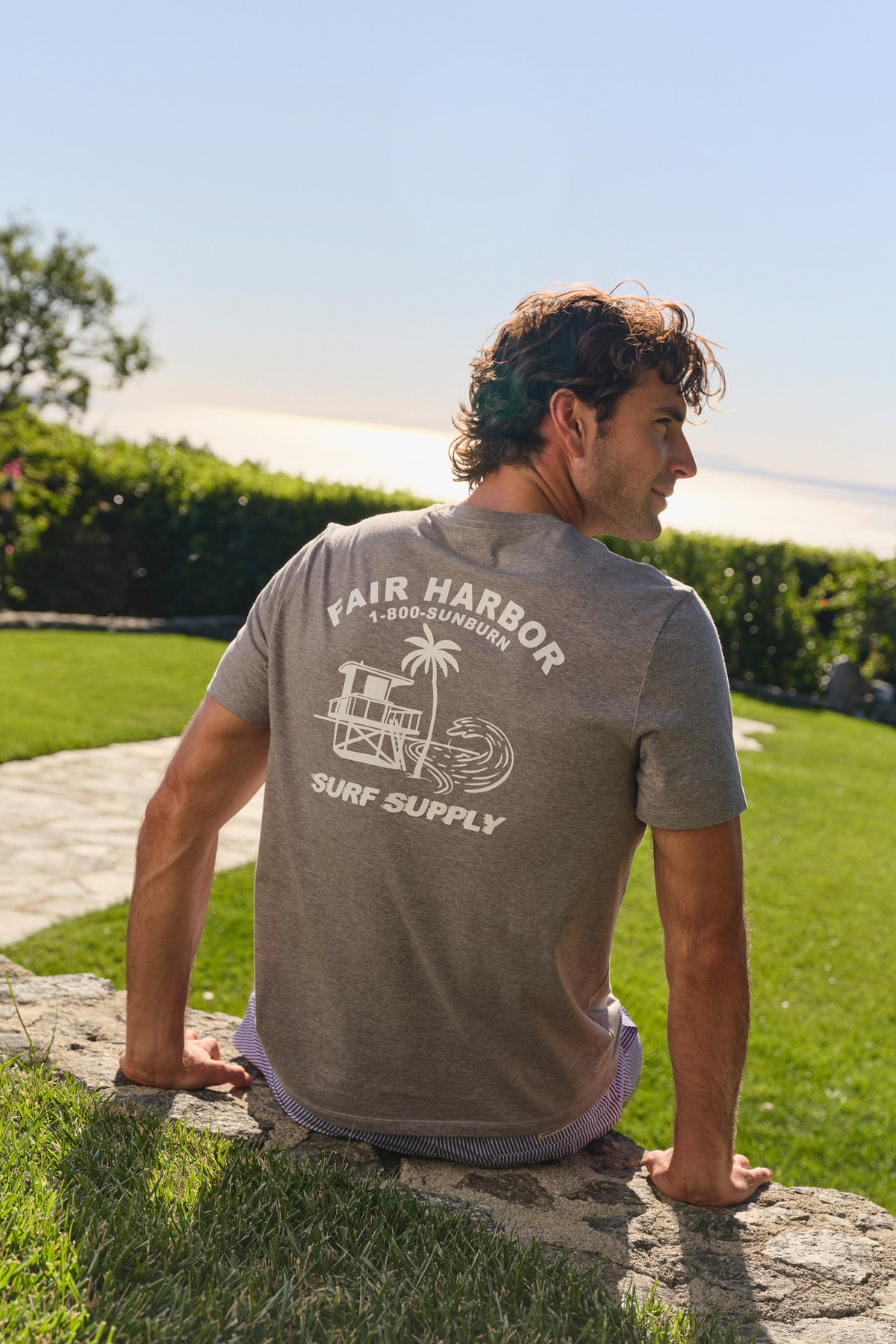 Man wearing a taupe graphic tee with 