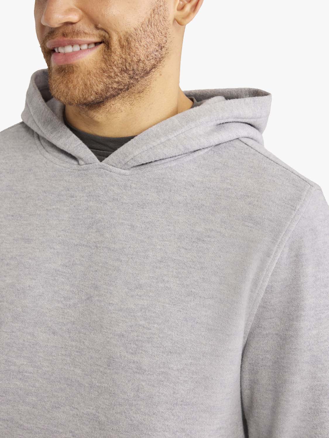Man wearing a heather grey blanket hoodie with a large hood and soft textile fabric.